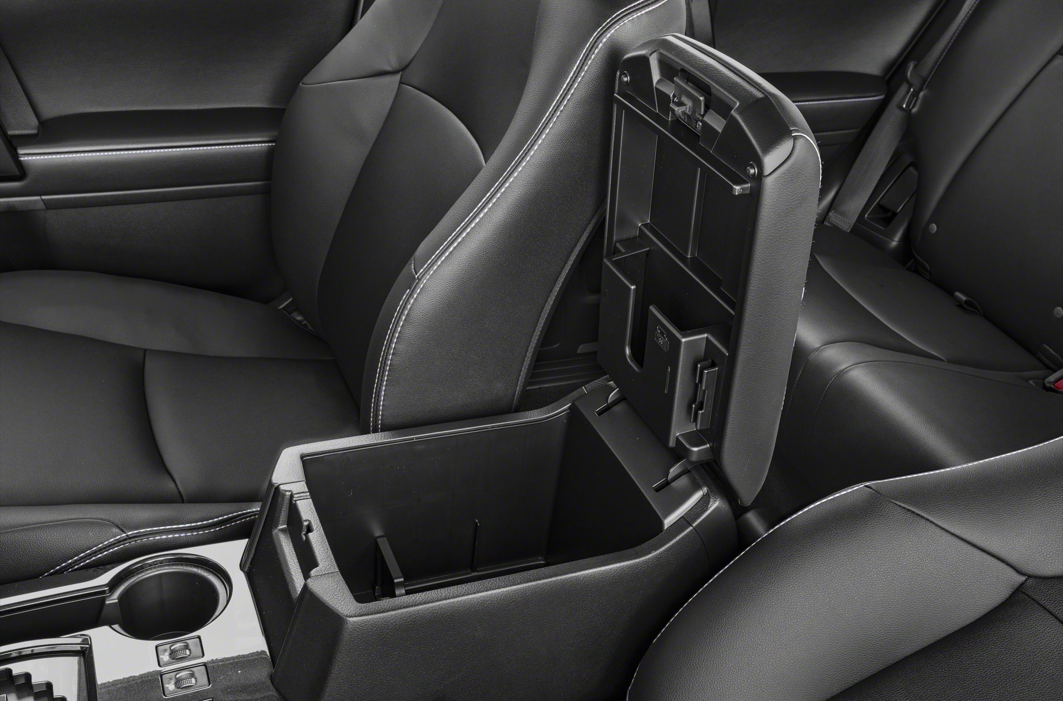 Open center console storage compartment with cup holder and black upholstery