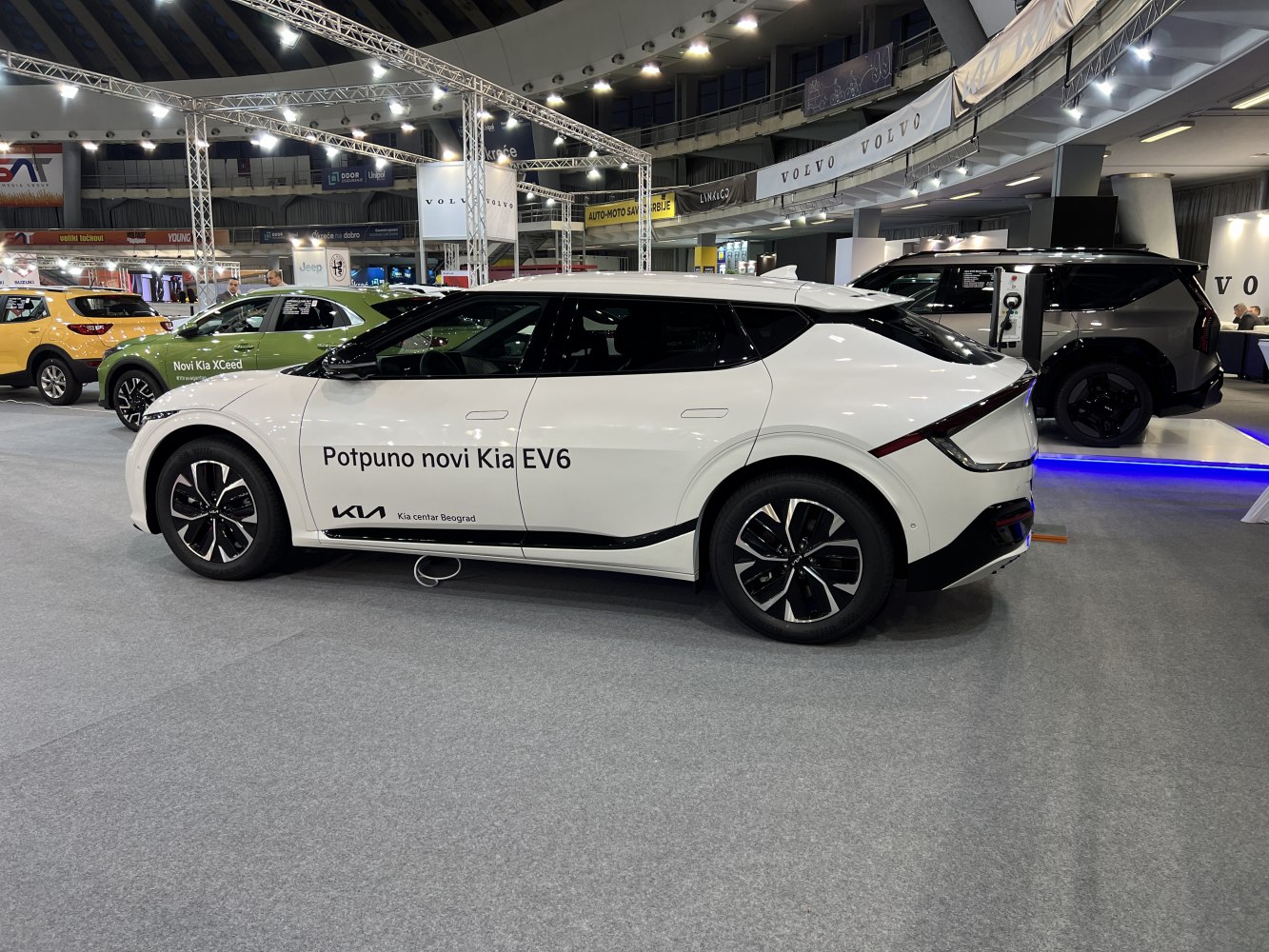 White electric vehicle side view with aerodynamic design and sleek wheels