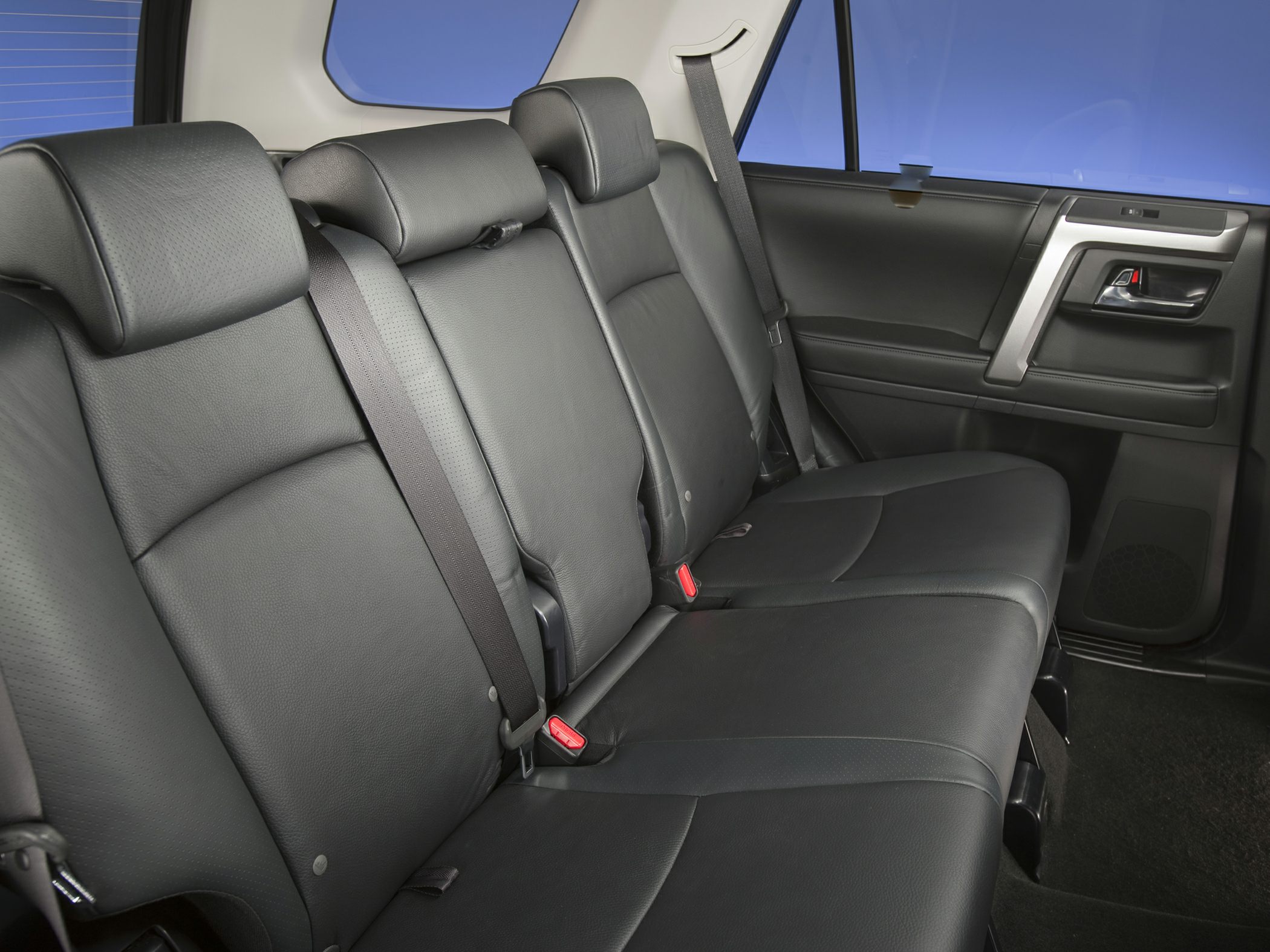 Rear seat interior with black leather upholstery and seat belts