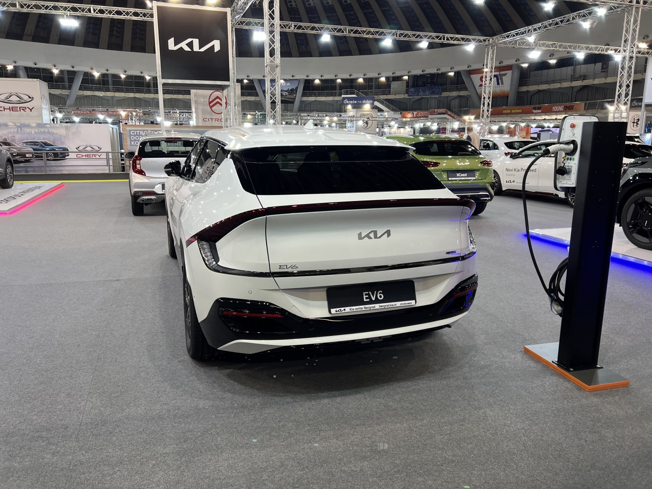Rear view of electric SUV with charging station at exhibition