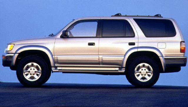 Side profile of silver 1996 SUV with roof rack and alloy wheels