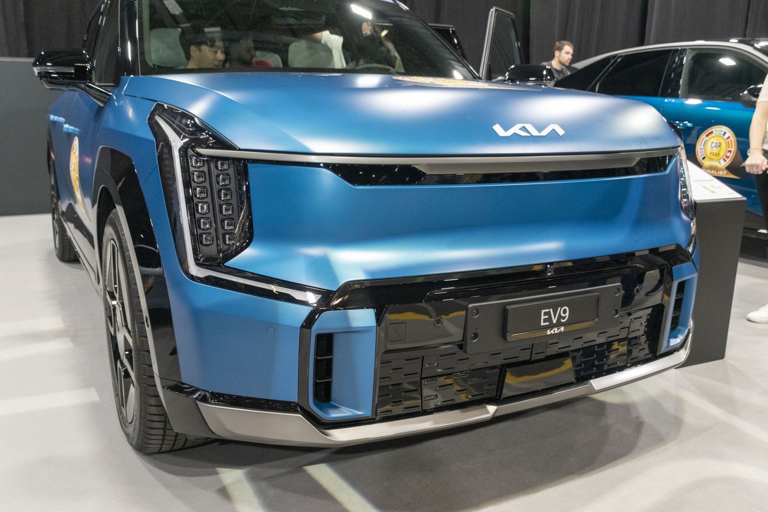 Futuristic LED headlights and aerodynamic front fascia of electric SUV.