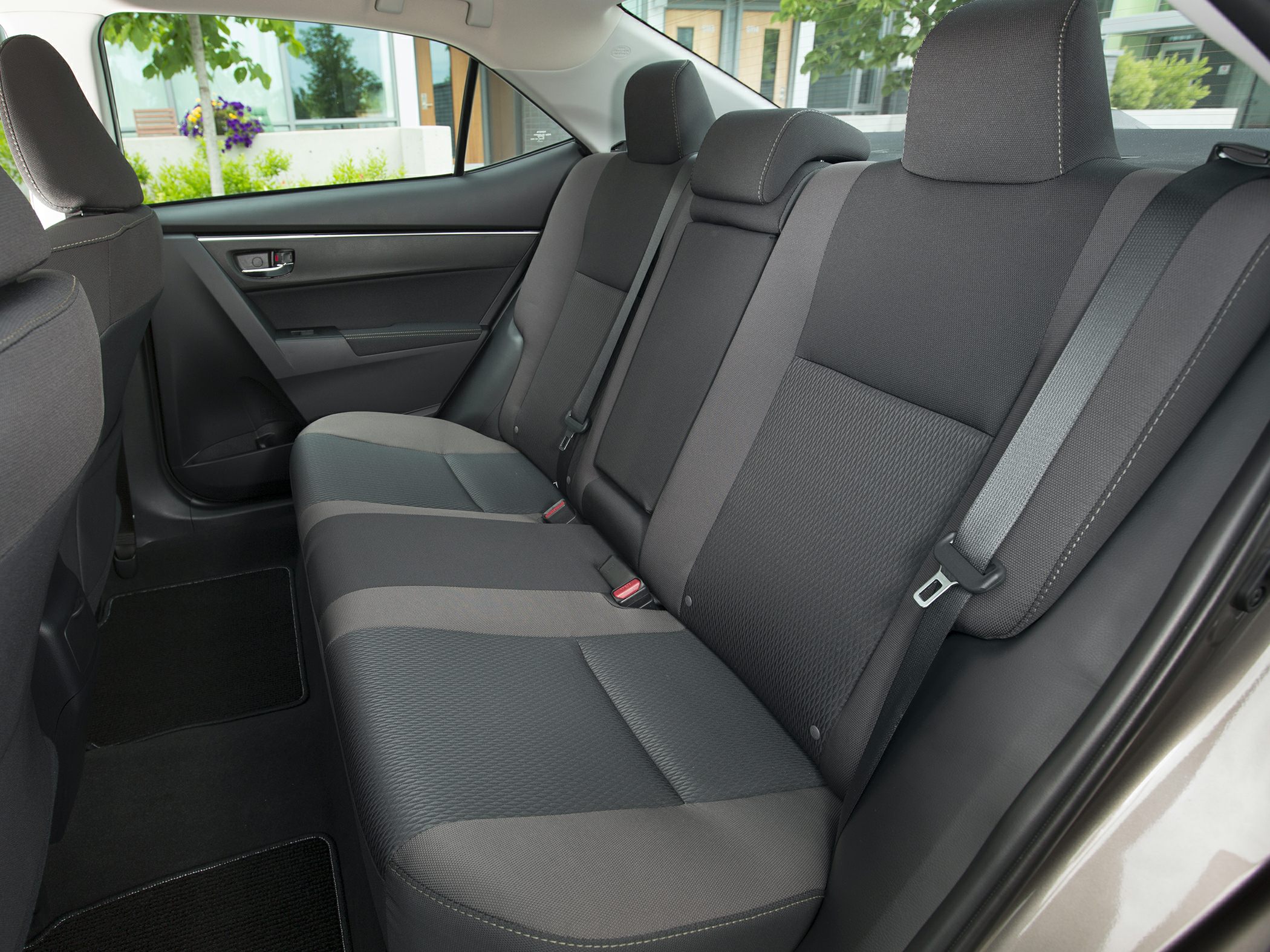 Rear seat fabric upholstery and interior design with seat belts and rear door panel.