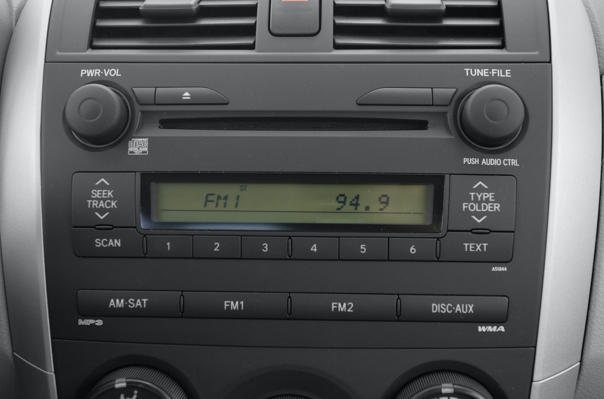 Close-up of car radio console with FM display and control buttons