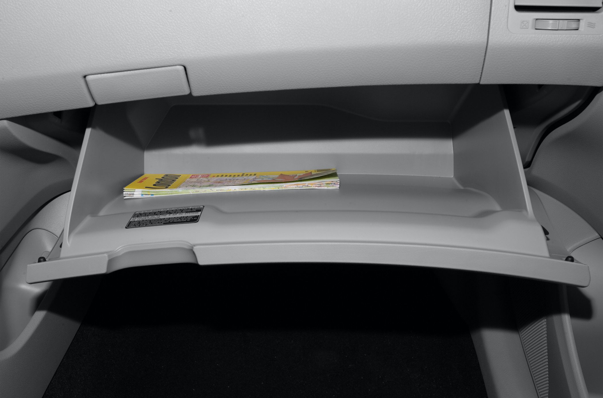 Open glove box compartment with stored documents in vehicle interior