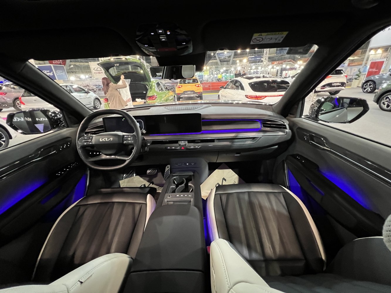 Digital dashboard, ambient blue lighting, front seats with black and white leather upholstery
