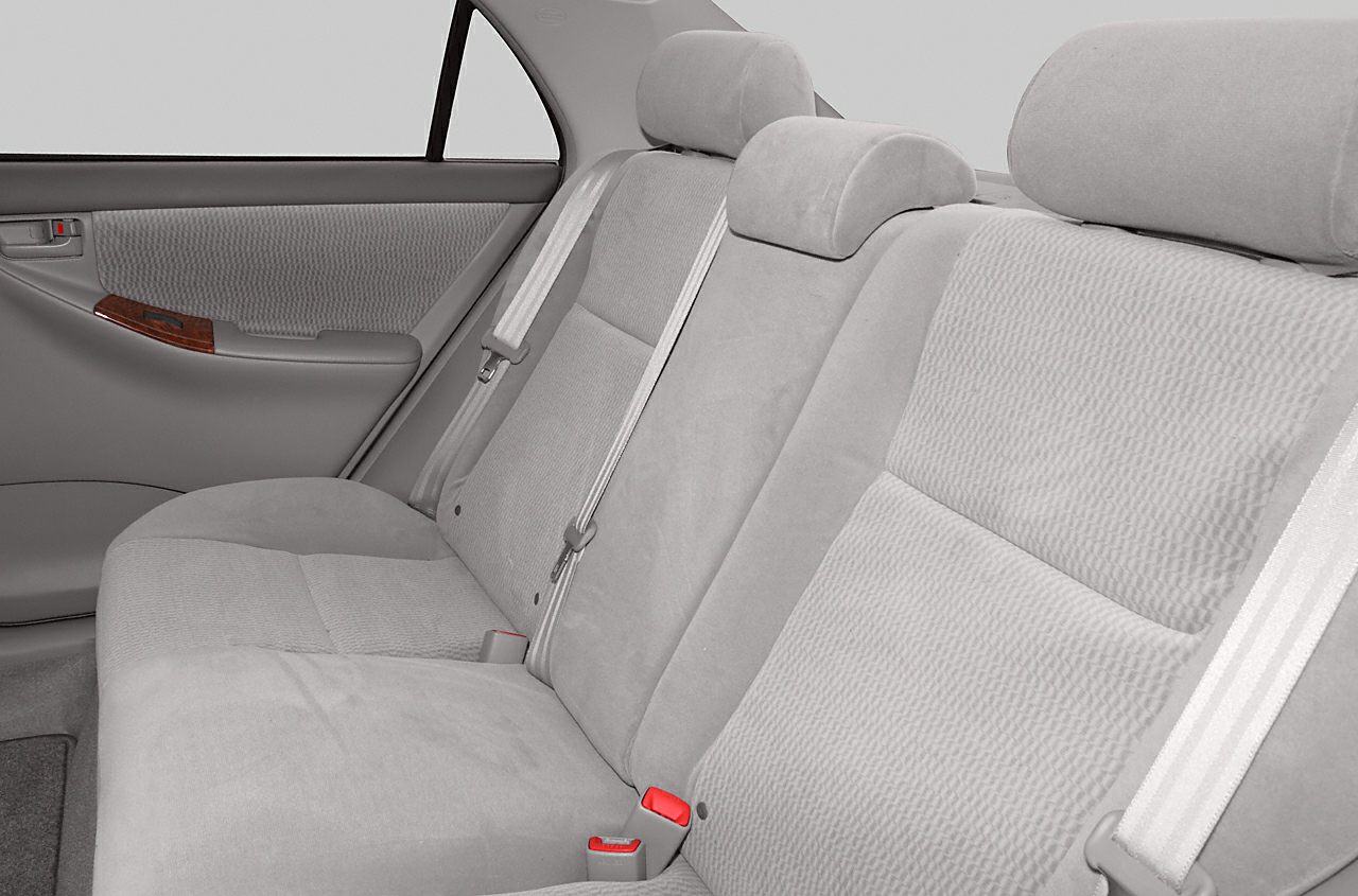 Fabric rear seats with seatbelts and door panel in a car interior.