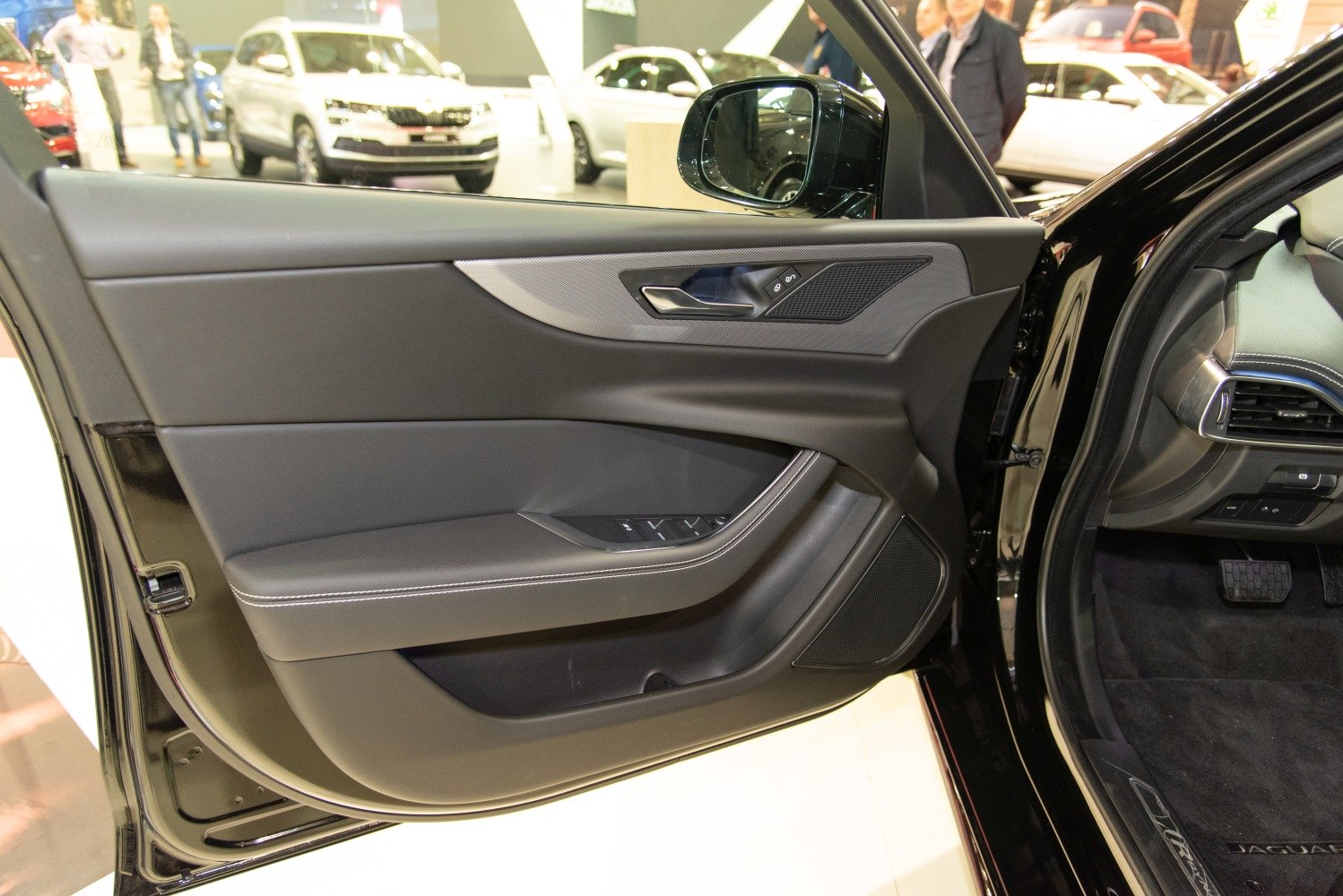 Driver-side interior door panel with controls and handle