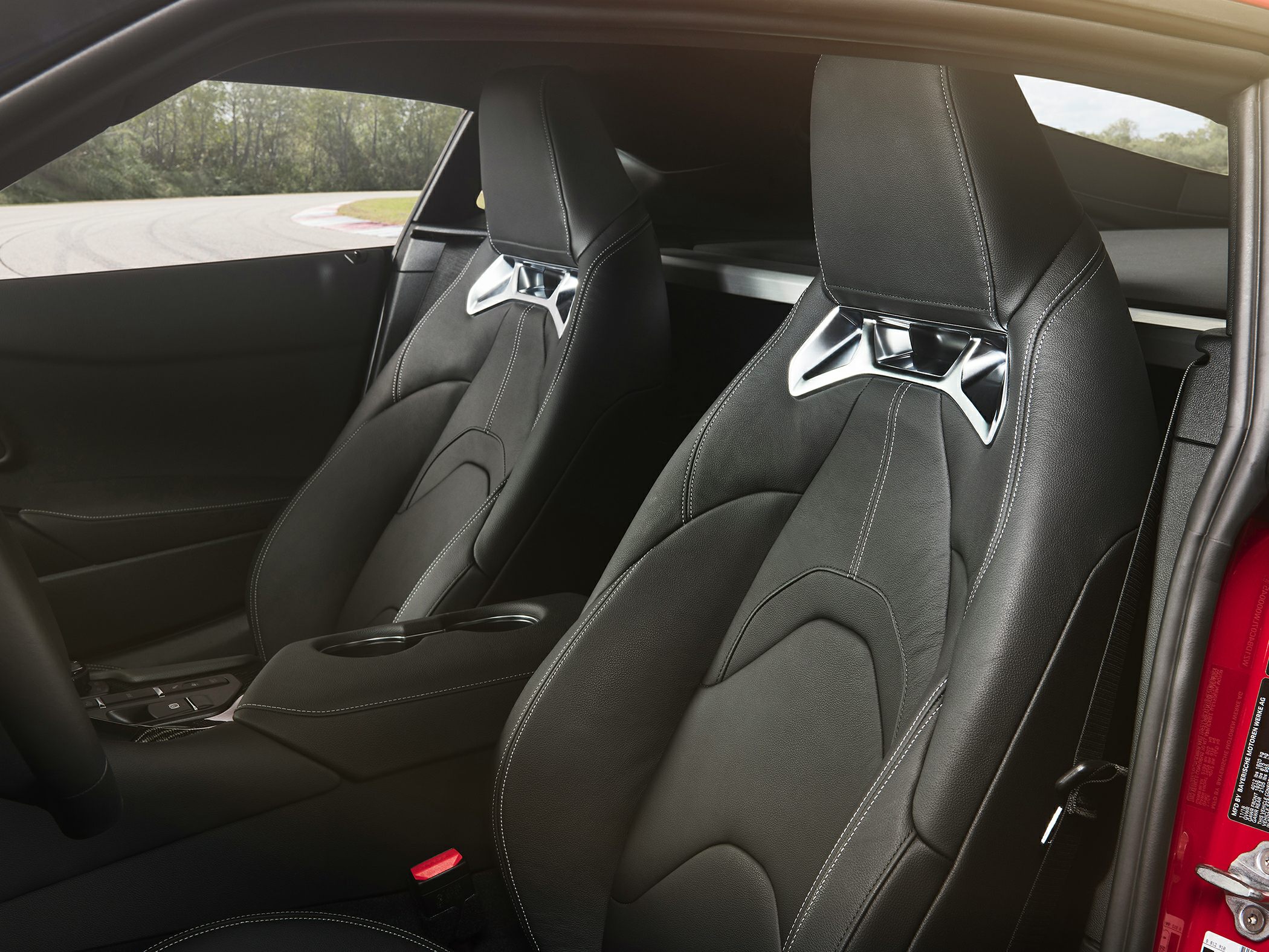 Black leather sports seats with metallic accents inside a modern sports car.