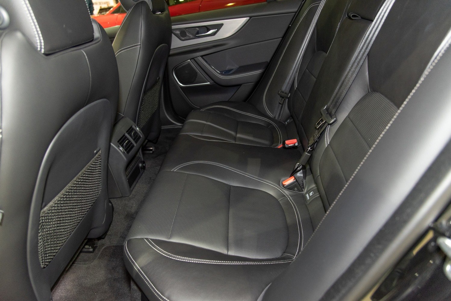 Rear leather seats with white stitching and spacious legroom.