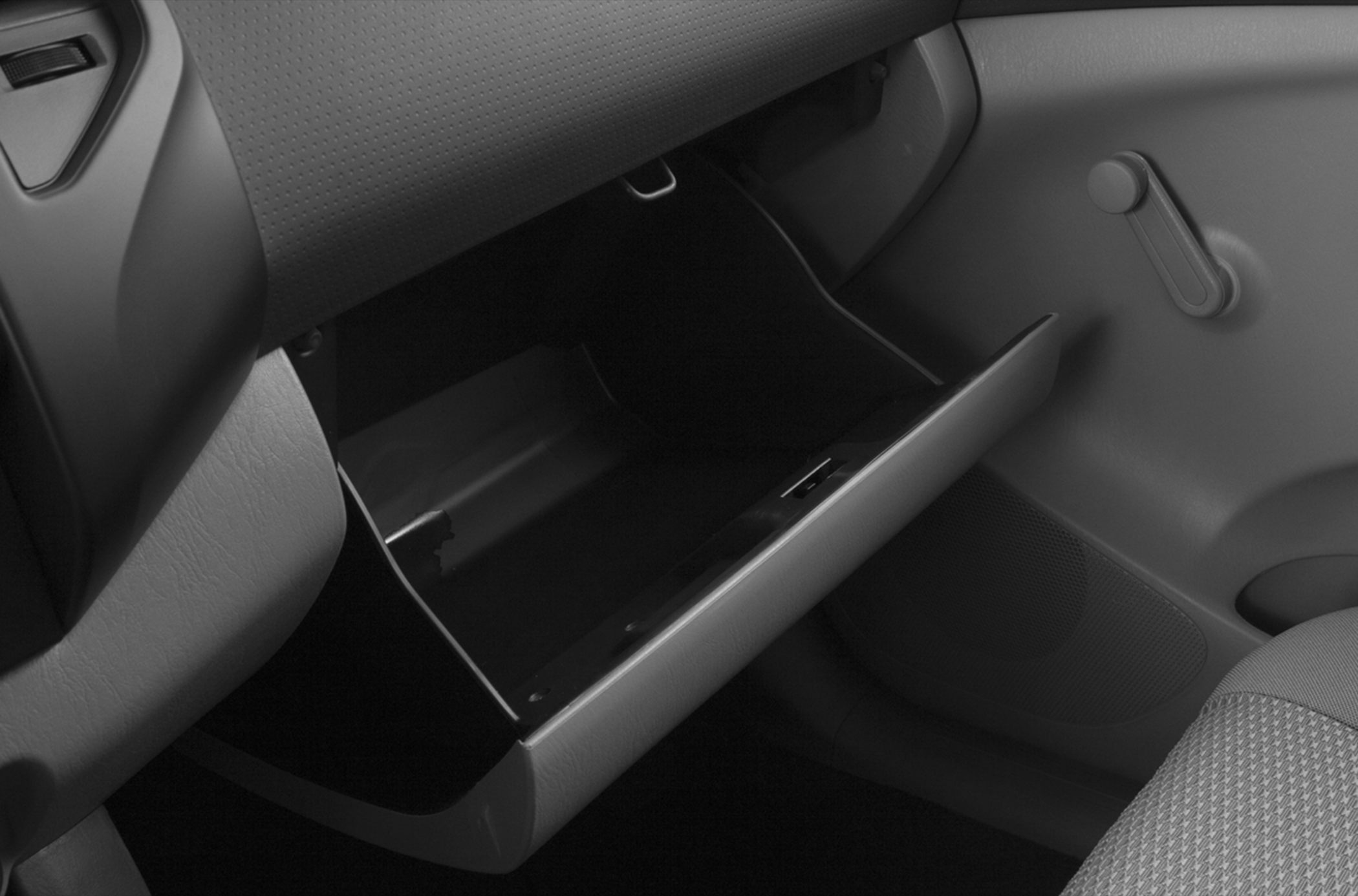 Open glove compartment and door interior with manual window crank