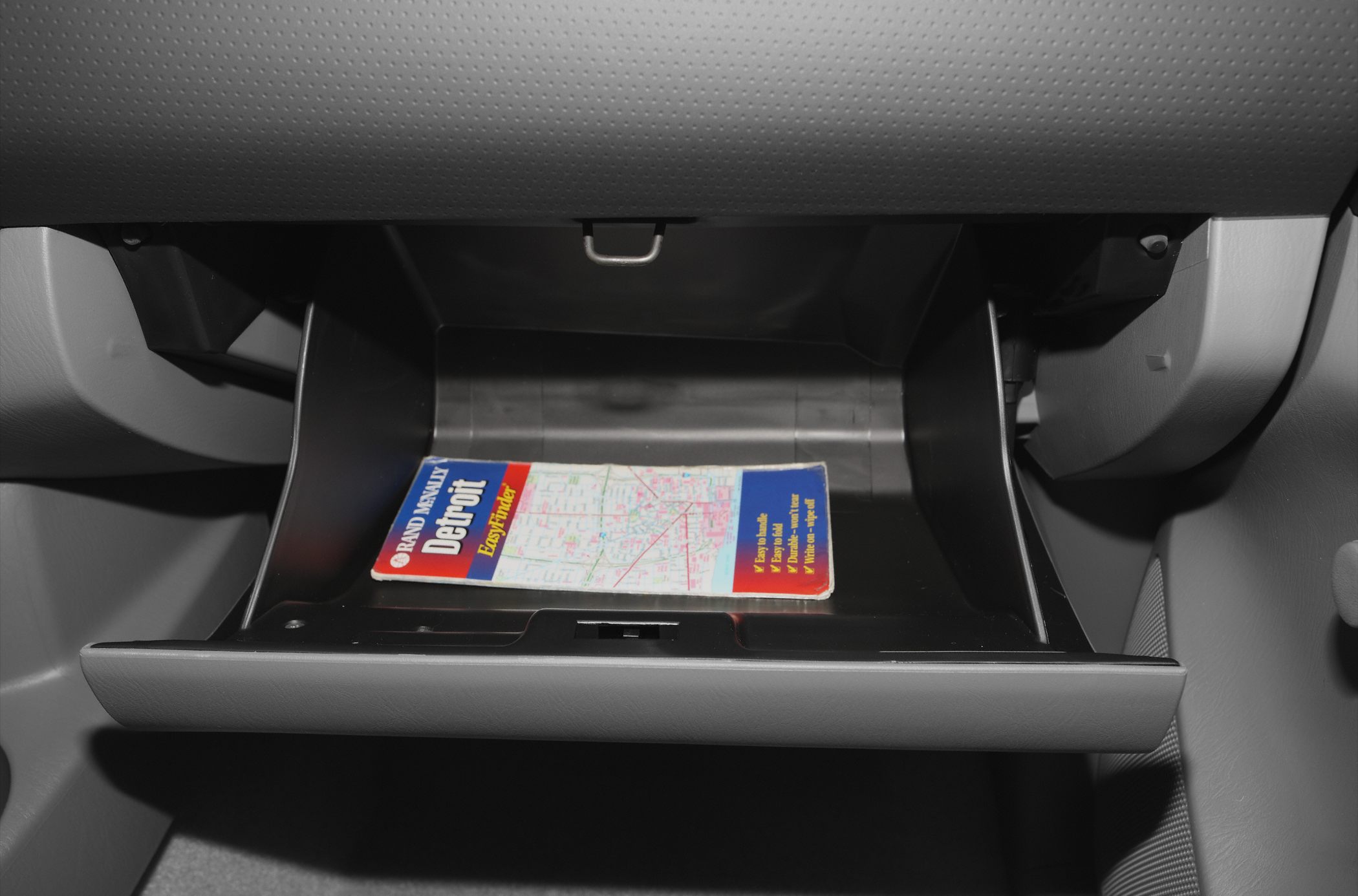 Open glove compartment with a folded map inside