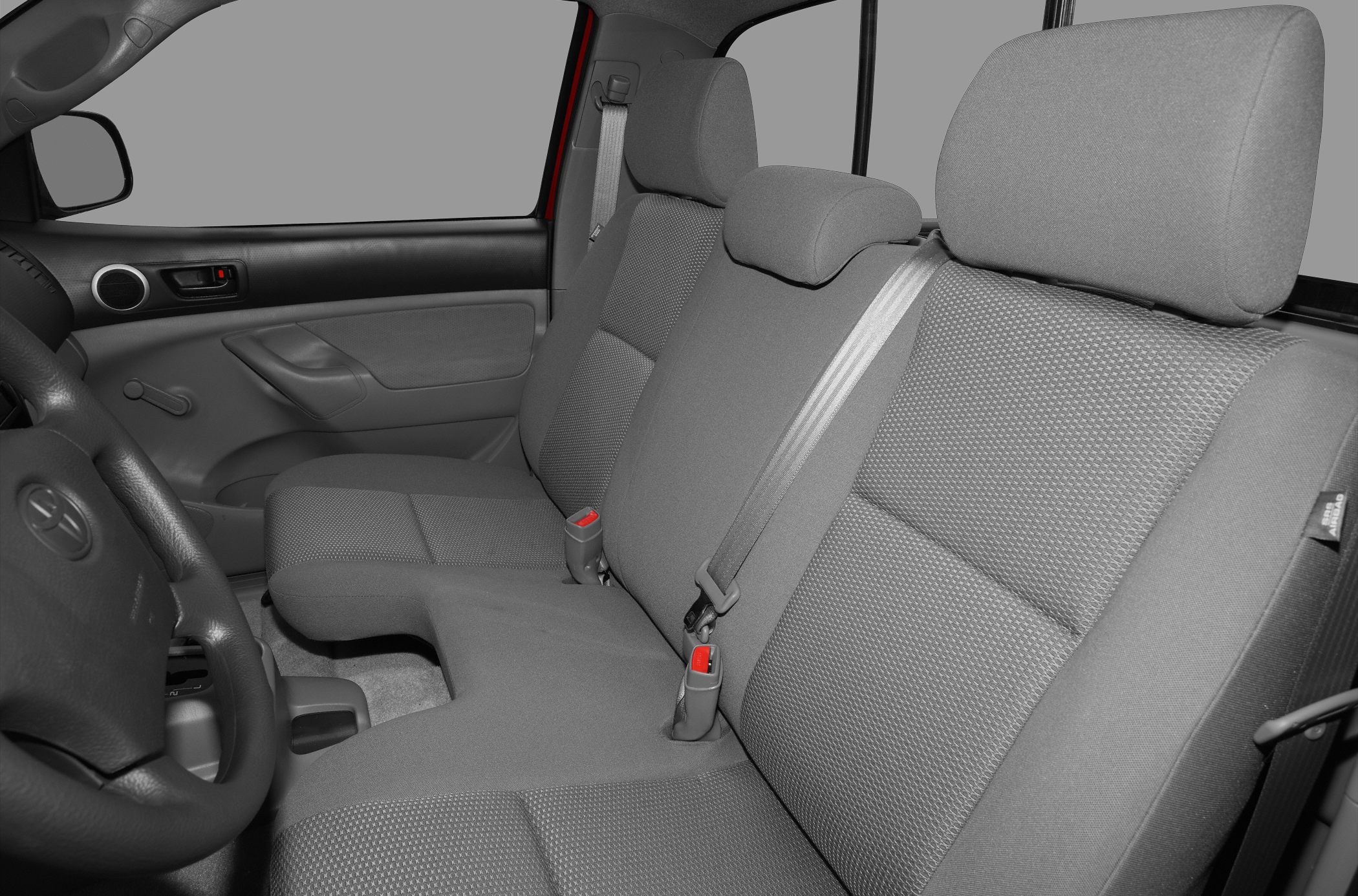 Front row bench seating with textured upholstery and integrated seat belts.