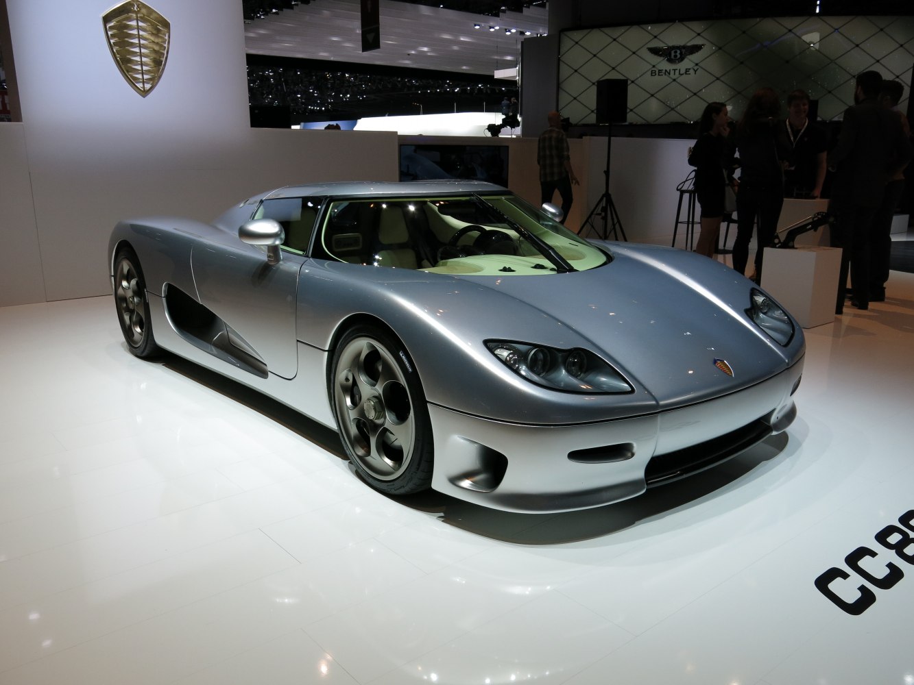 Silver supercar with aerodynamic body and circular rim wheels