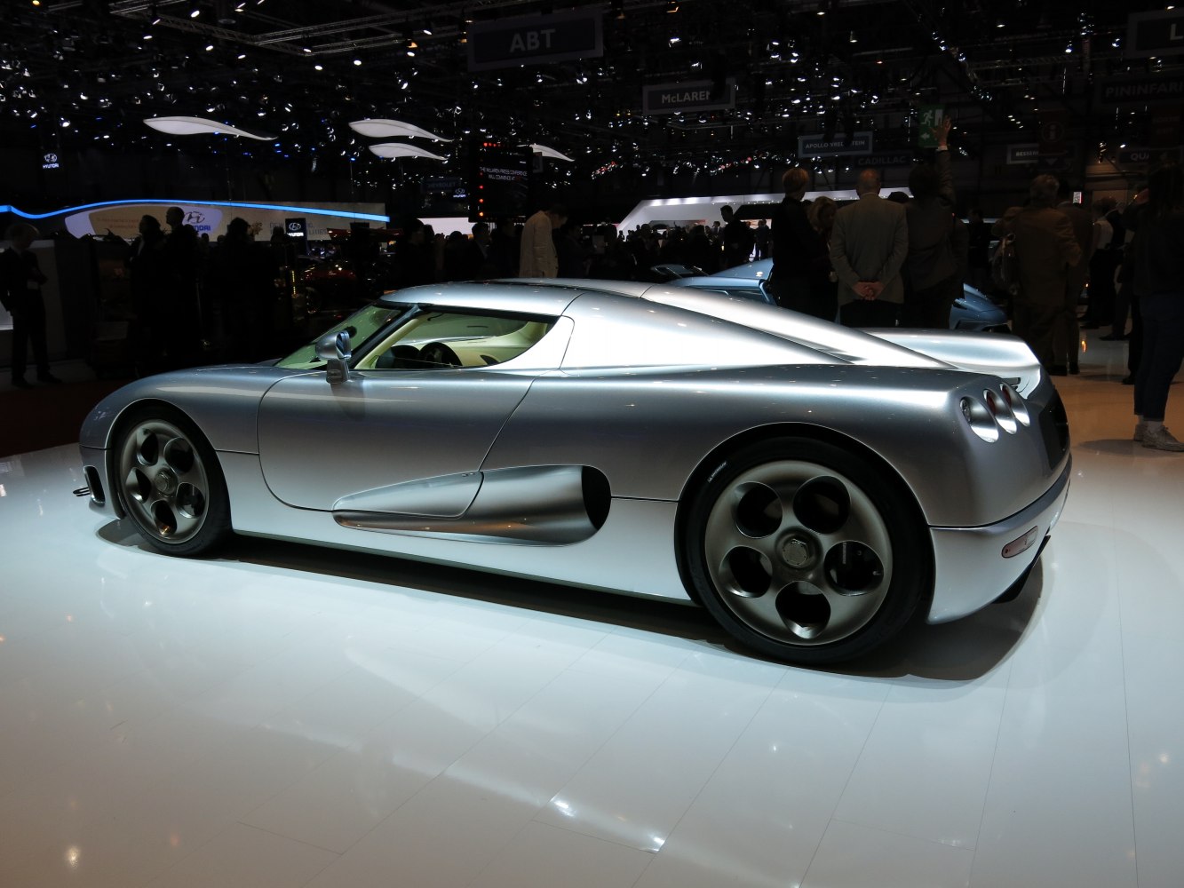 Sleek silver sports car side profile with aerodynamic body and unique wheels