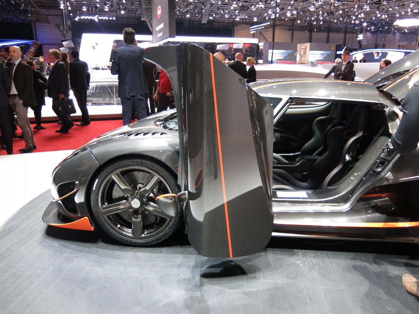 Carbon fiber butterfly door with visible racing seats and wheel