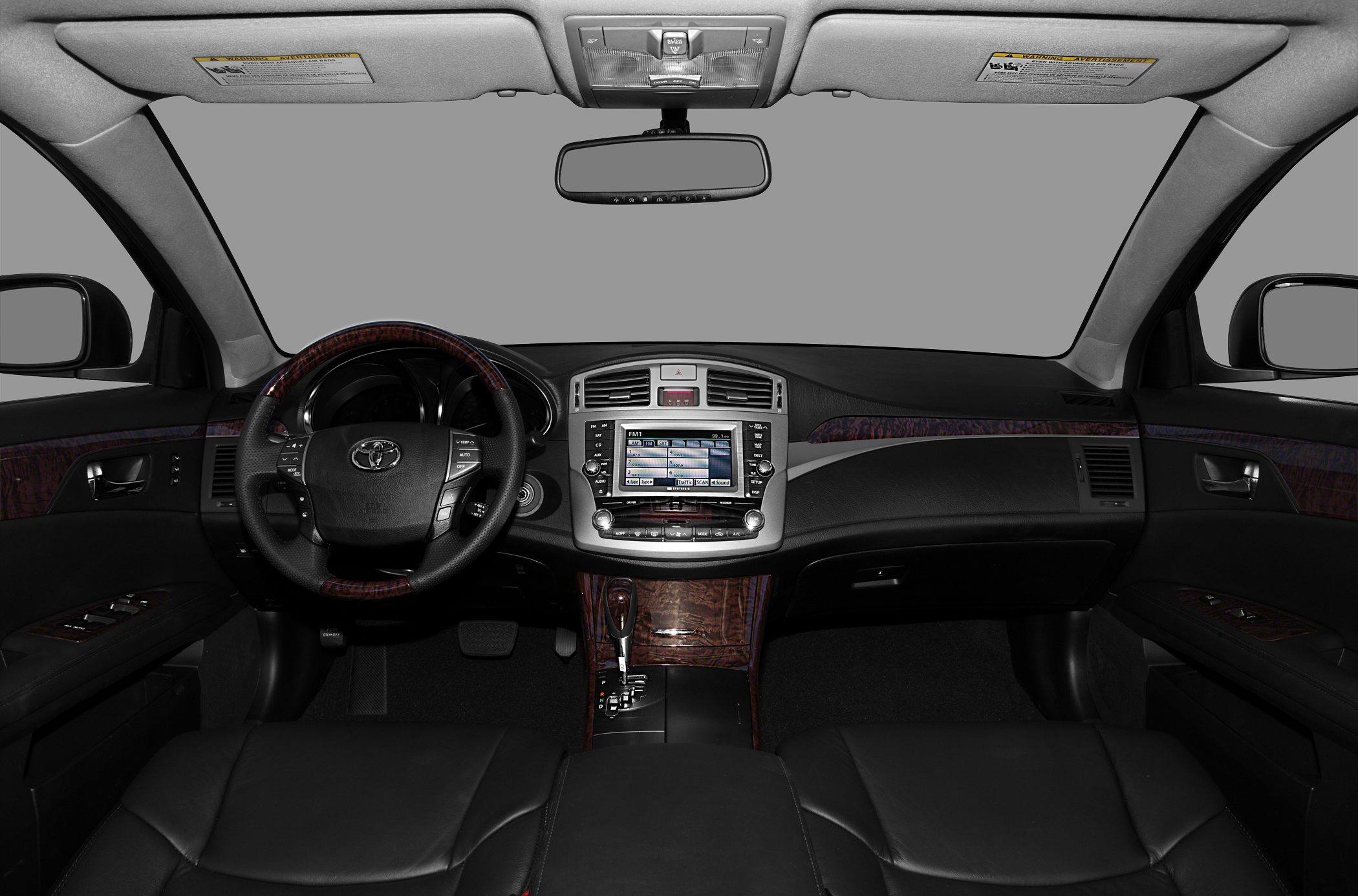 Dashboard and steering wheel with infotainment and wood trim accents