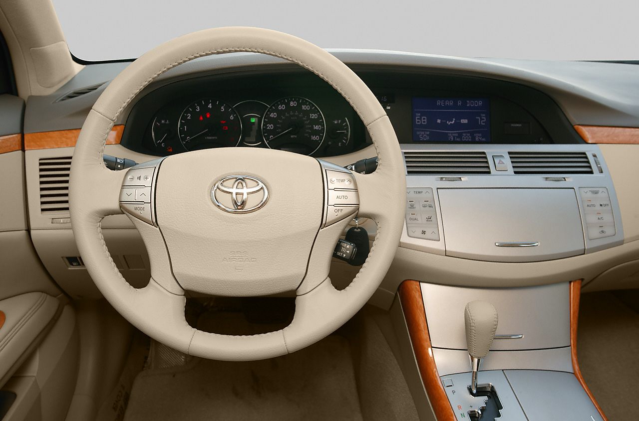 Beige steering wheel and dashboard with climate controls and gear shift