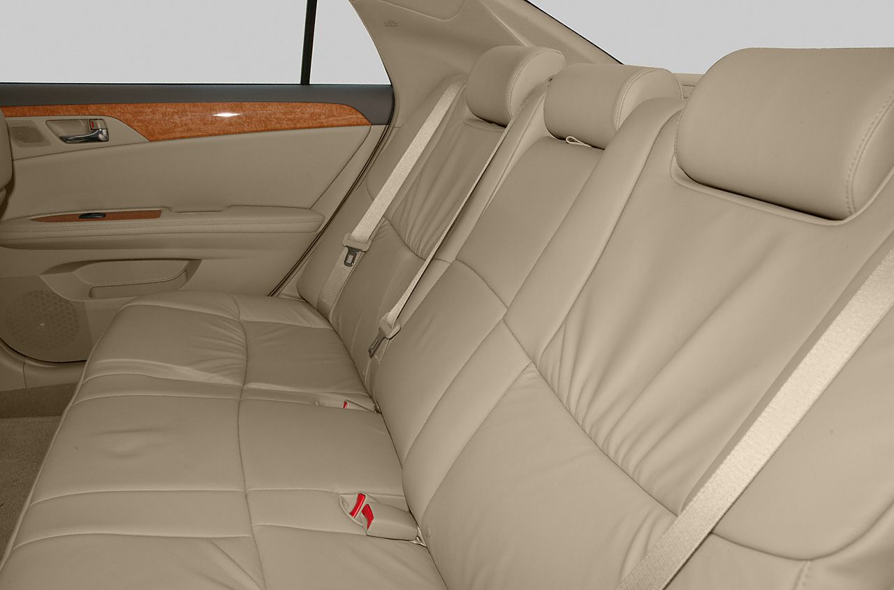 Beige leather rear seating with integrated headrests and wood trim door panel