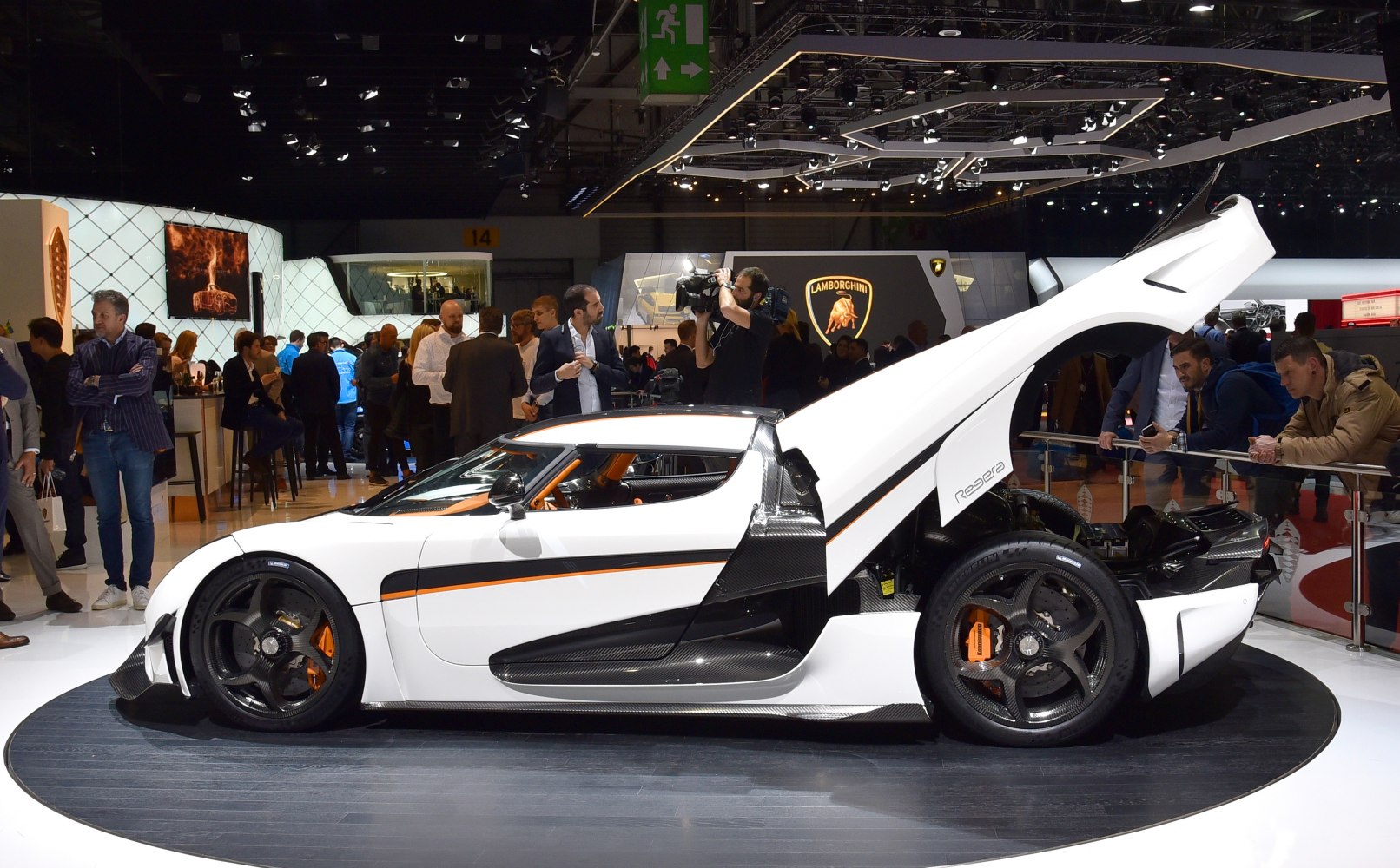 Side profile of a high-performance supercar with butterfly door open and carbon fiber details