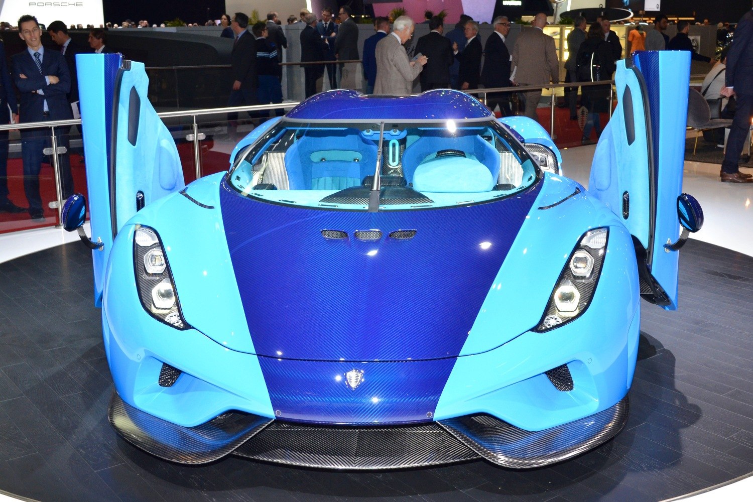 Front view with blue paint, carbon fiber hood, and open scissor doors