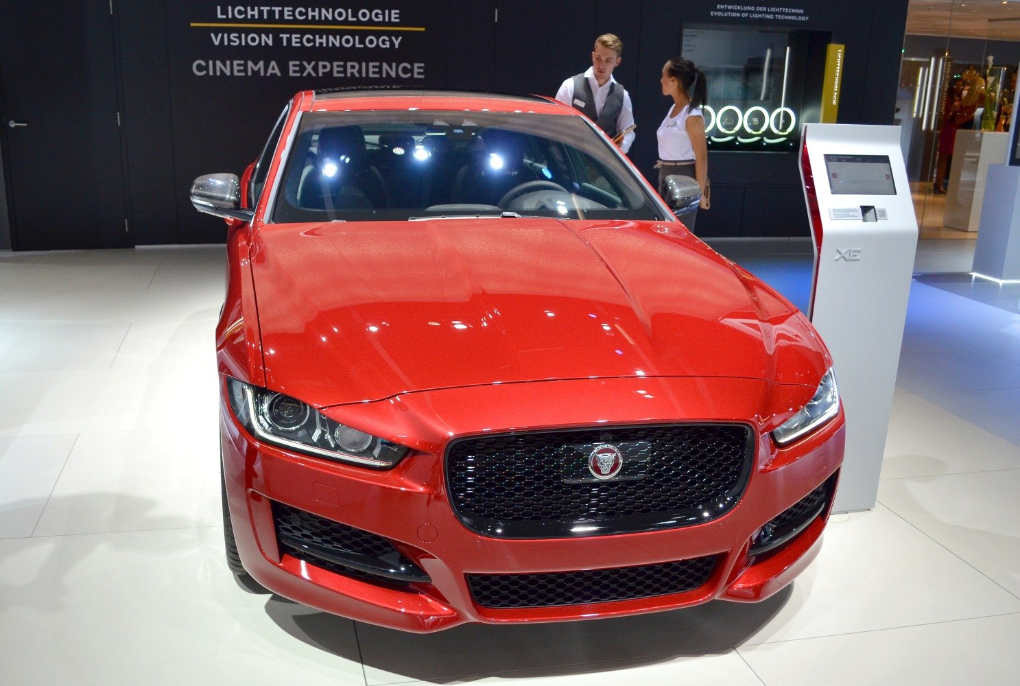 Red car front with LED headlamps and black mesh grille
