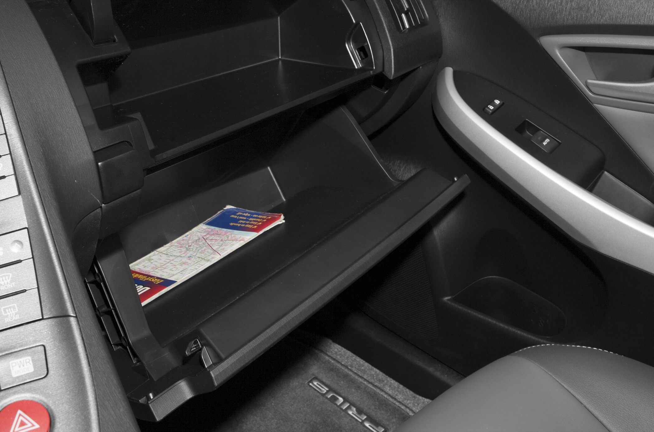 Open glove compartment with storage map and visible door controls