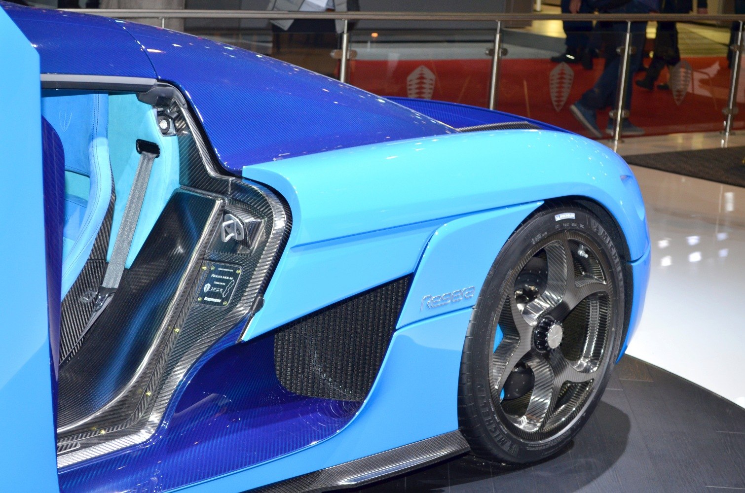 Blue sports car side with carbon fiber door frame and aerodynamic design