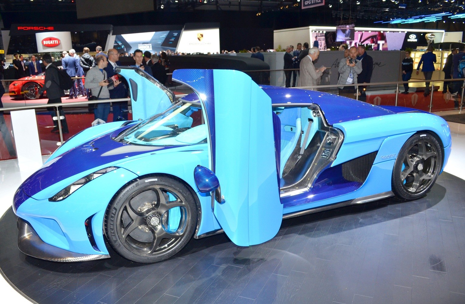 Open dihedral doors and carbon fiber wheels on a blue hypercar