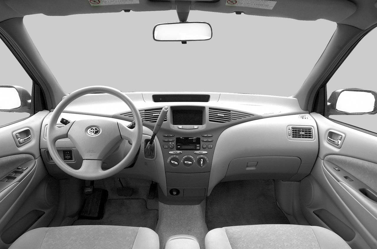 Dashboard and steering wheel with central console and seating layout.
