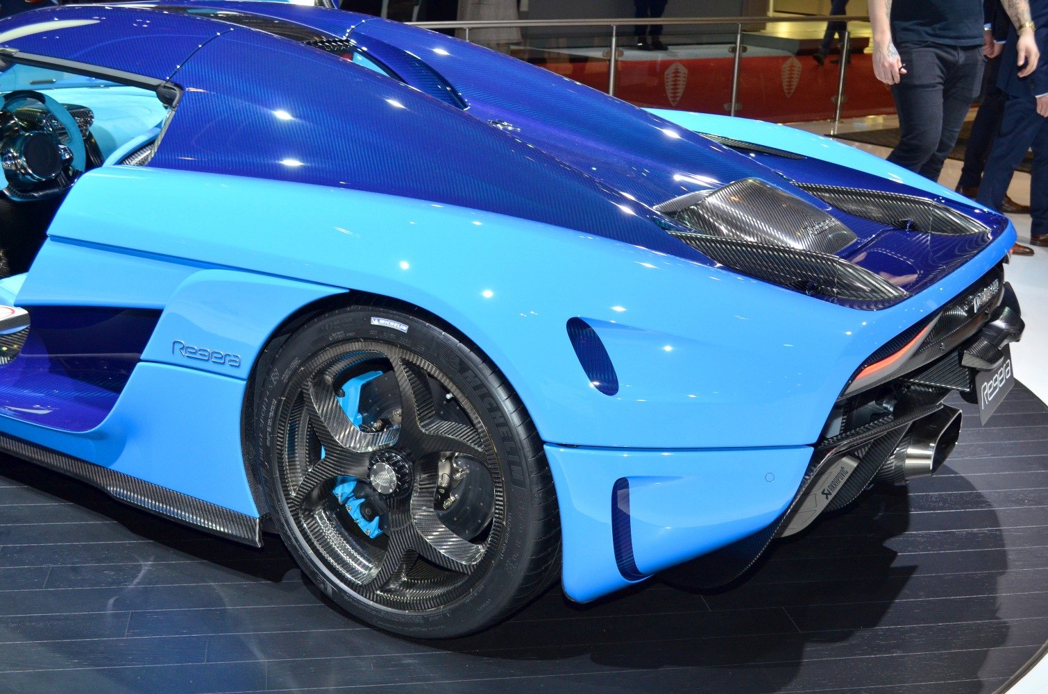 Rear close-up with carbon fiber wheels and aerodynamic blue body.