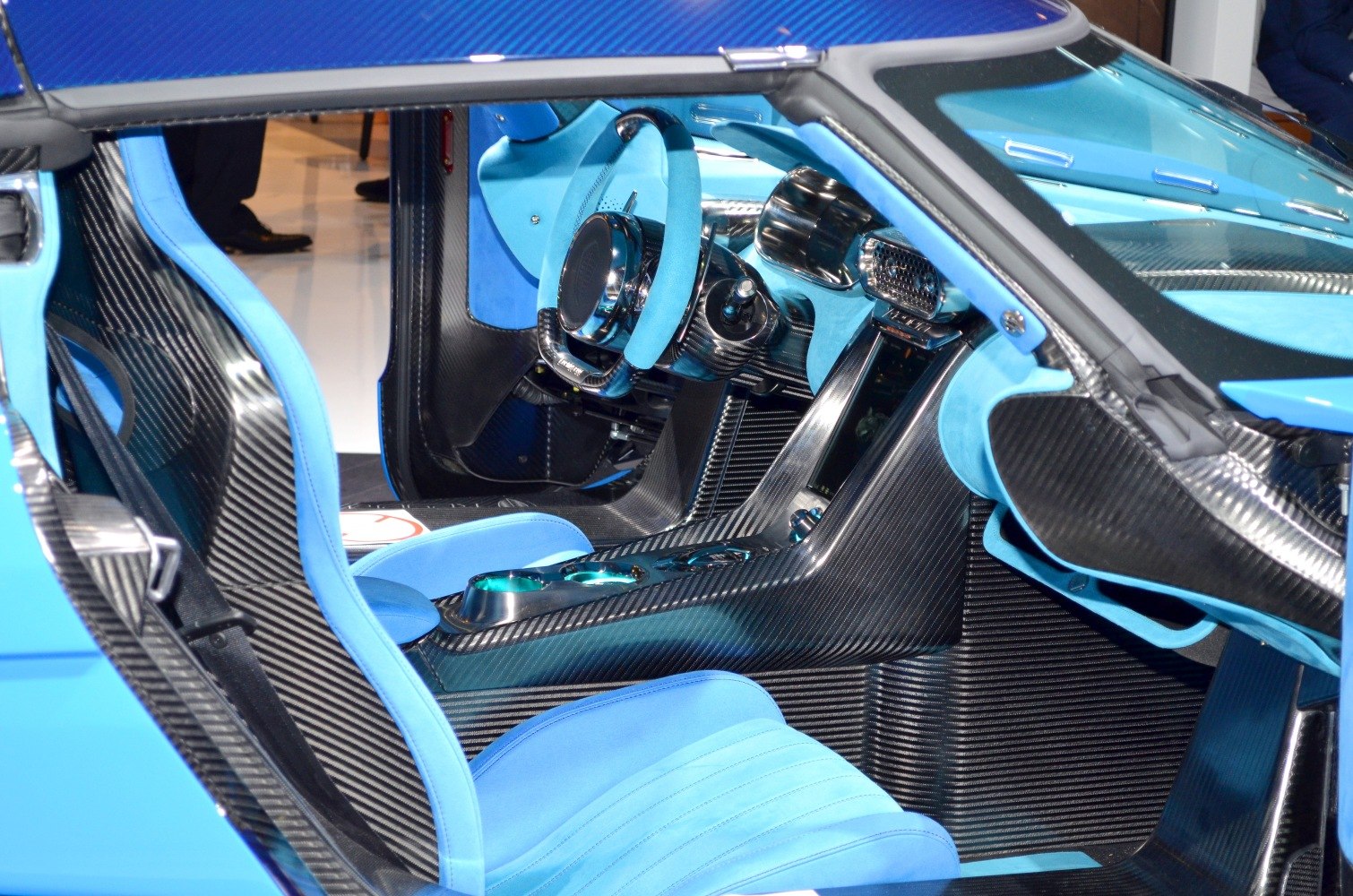 Carbon fiber interior with blue upholstery and advanced controls.