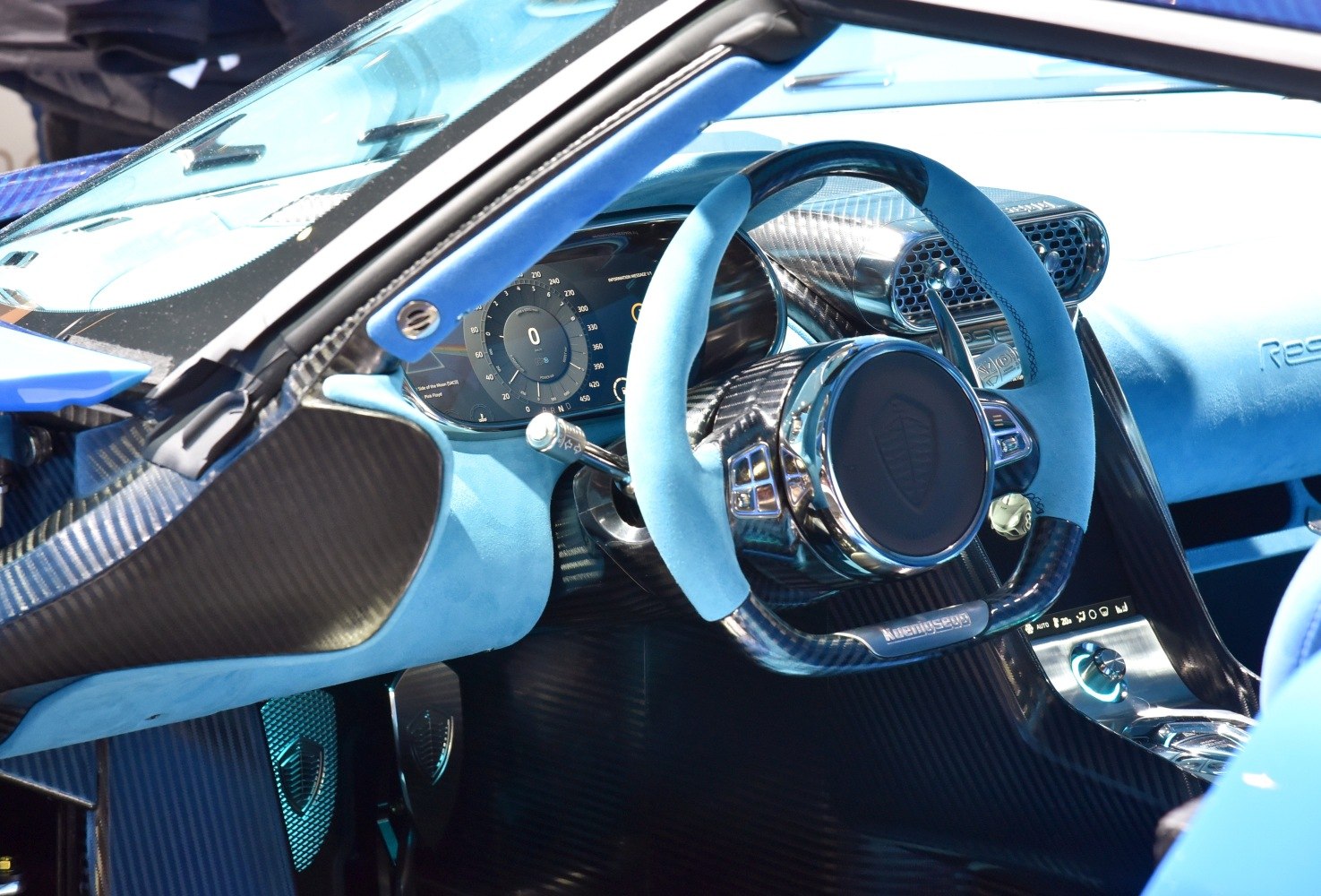 Blue Alcantara steering wheel with carbon fiber trim and digital dashboard