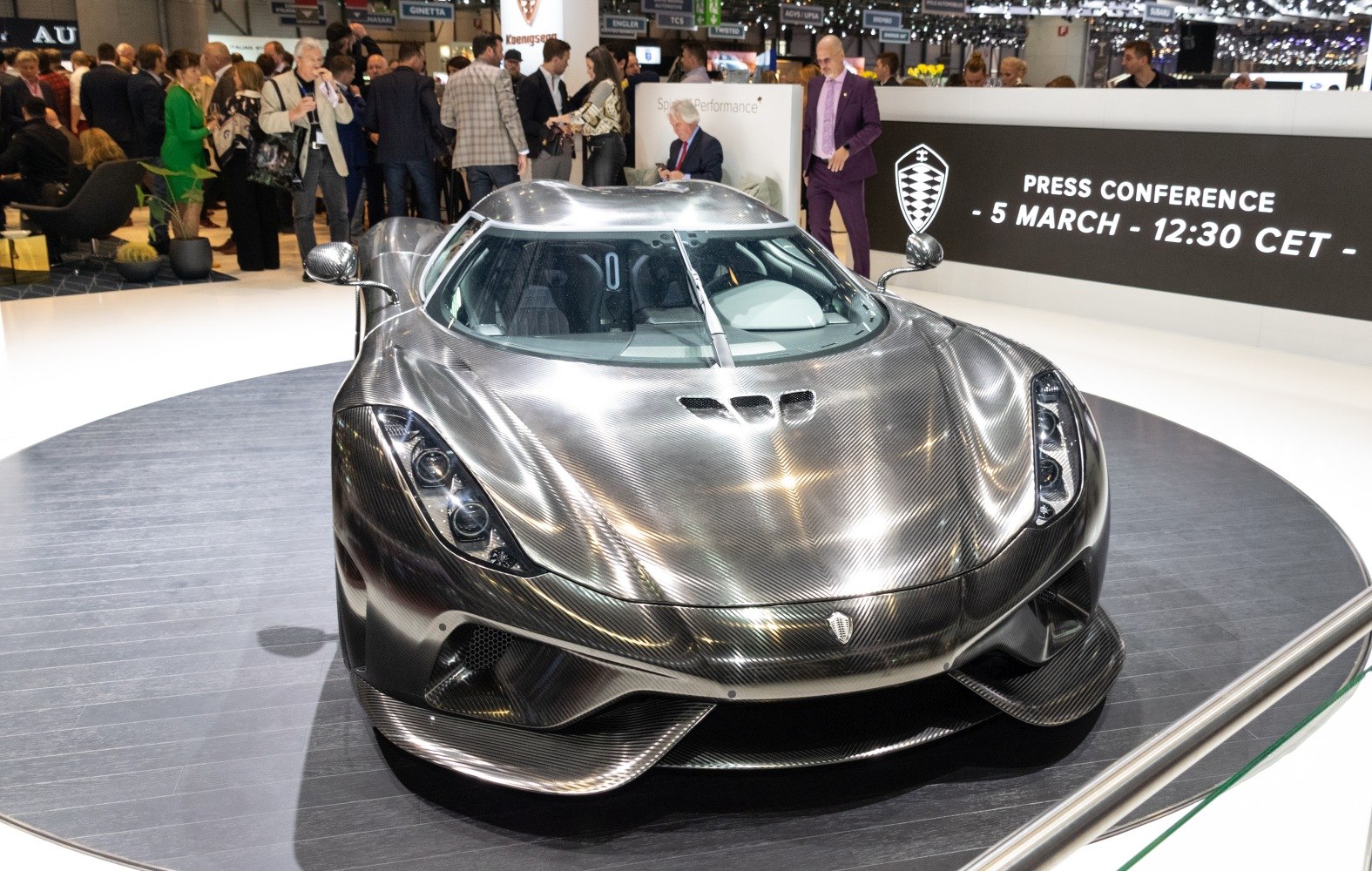 Front view of a carbon fiber hypercar with aerodynamic design and LED headlights