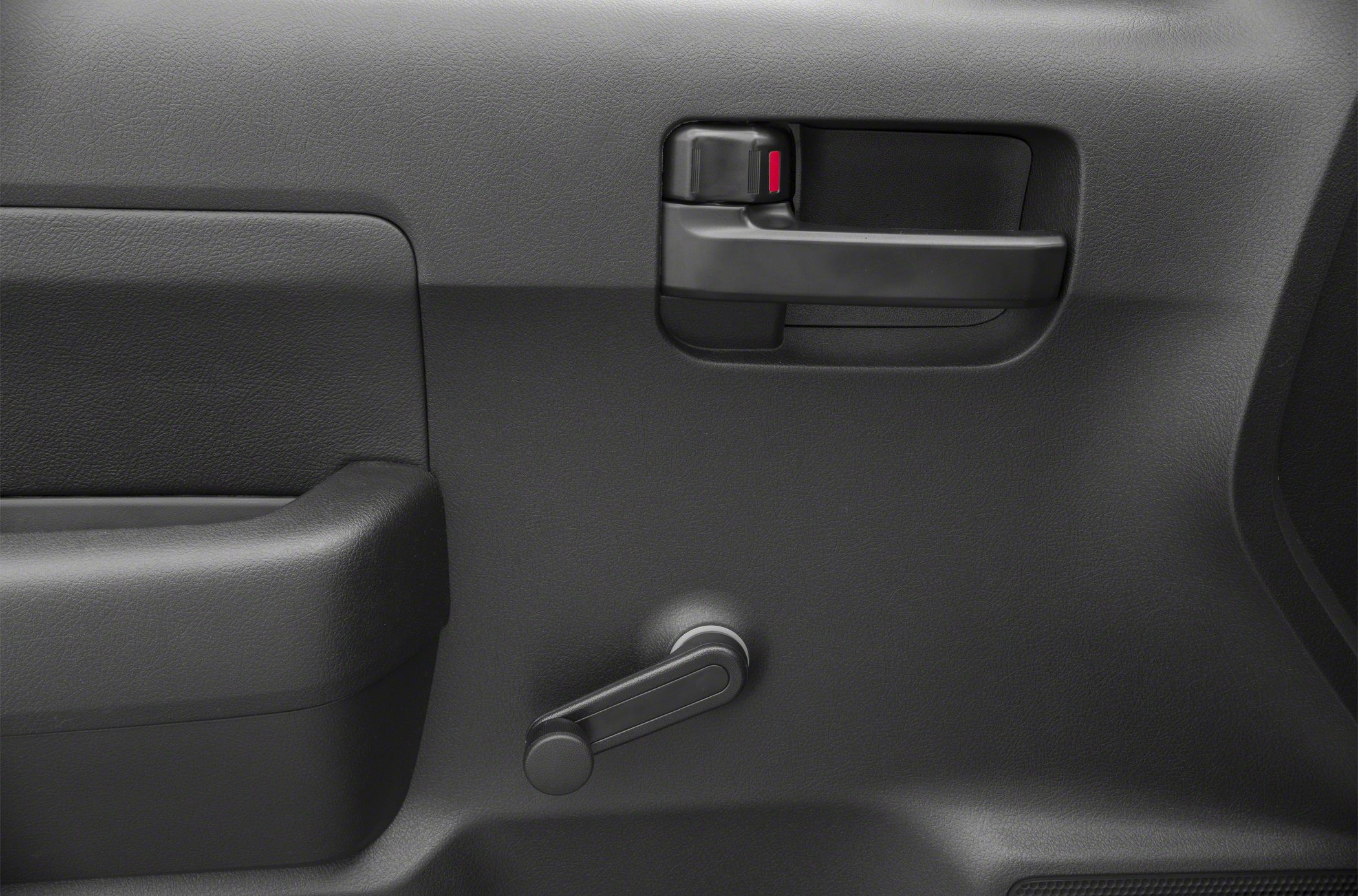 Manual window crank and black door handle on textured truck door panel