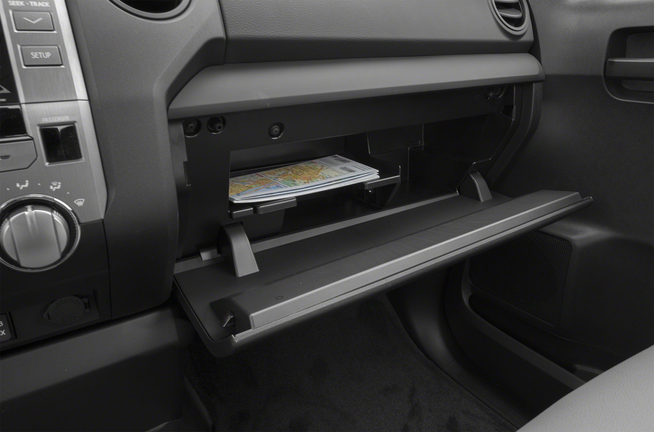 Open glove compartment with inset shelf holding a map
