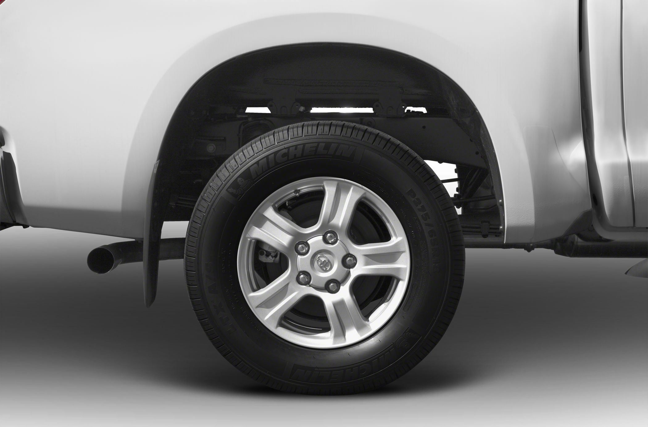 Rear wheel with Michelin tire and alloy rim under pickup truck fender.