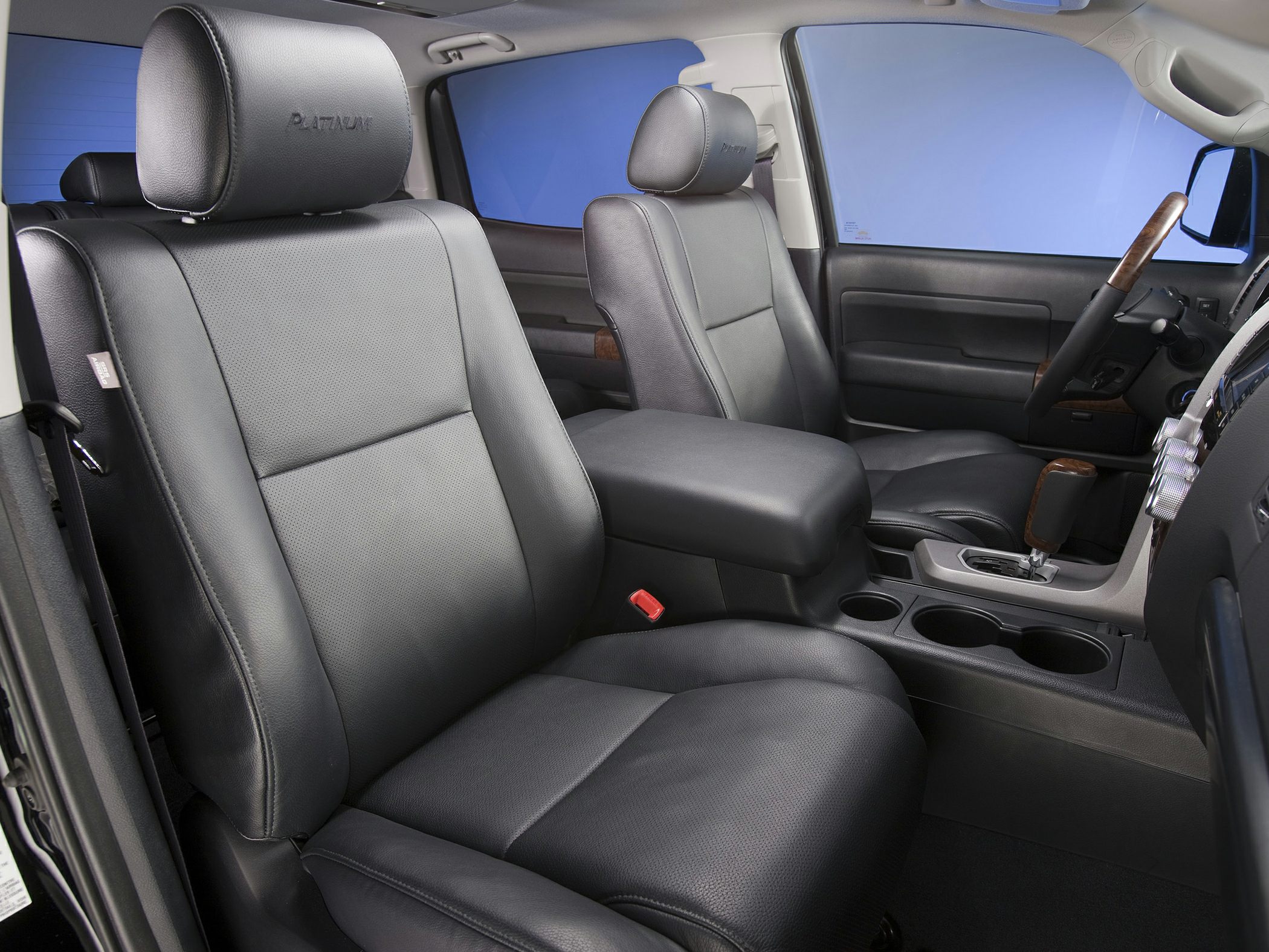 Black leather seats and spacious center console with wood trim and cup holders