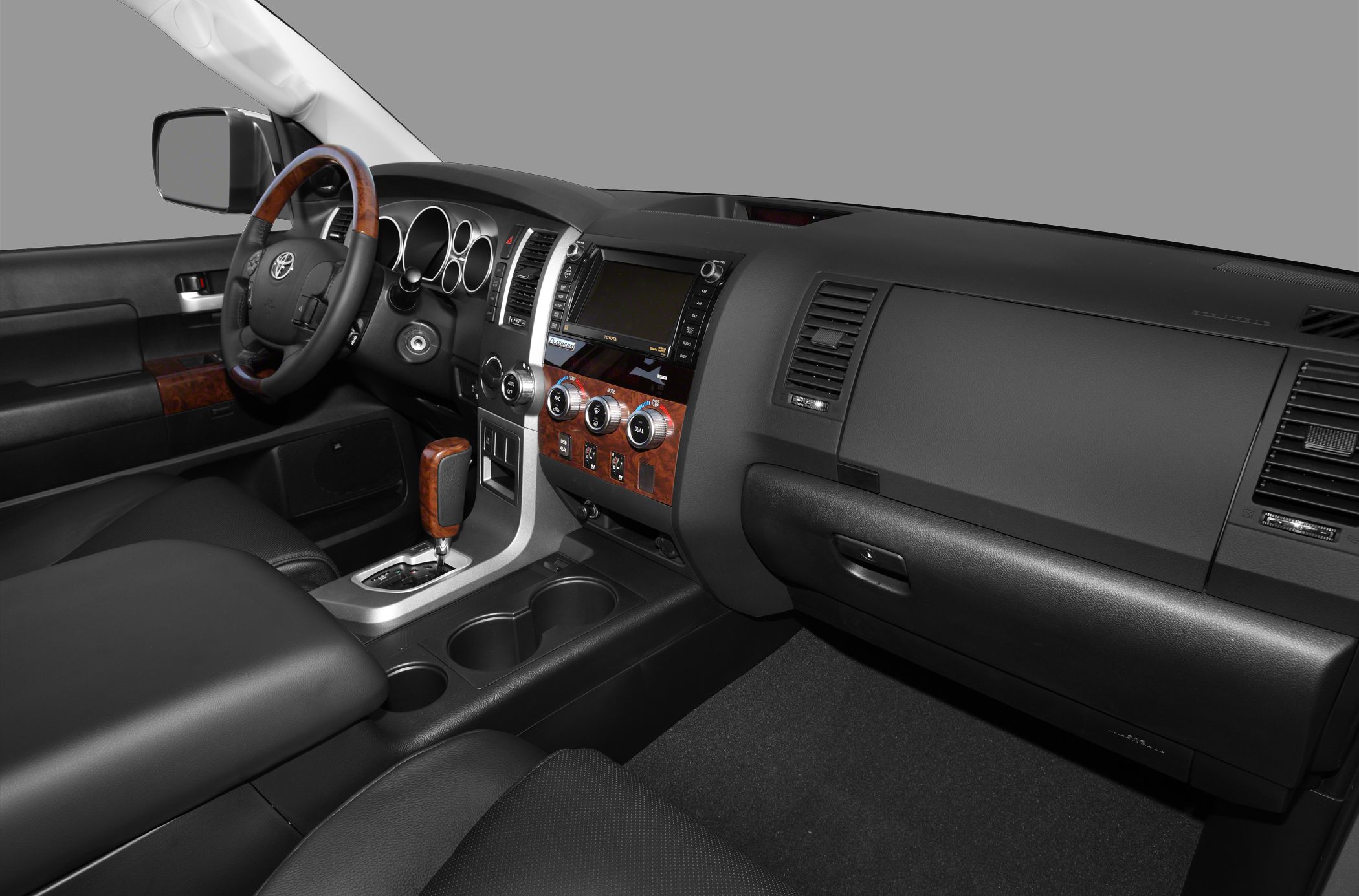 Interior with wood trim, multi-functional steering wheel, and climate control dials