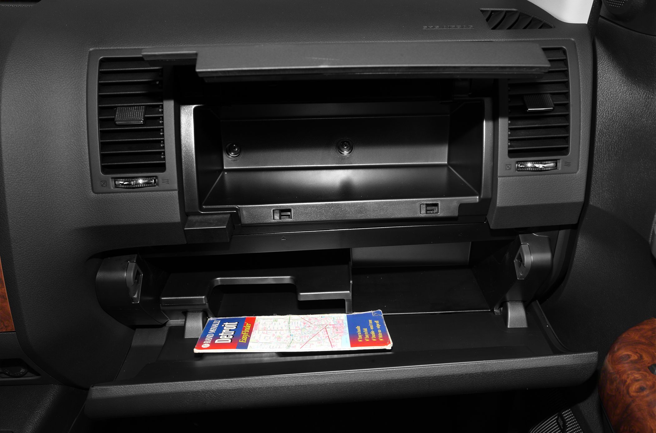 Dual-compartment glove box with map storage and air vents.