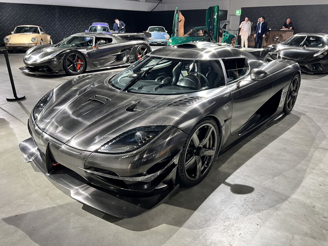 Carbon fiber supercar front-side view with aerodynamic design and sleek body.