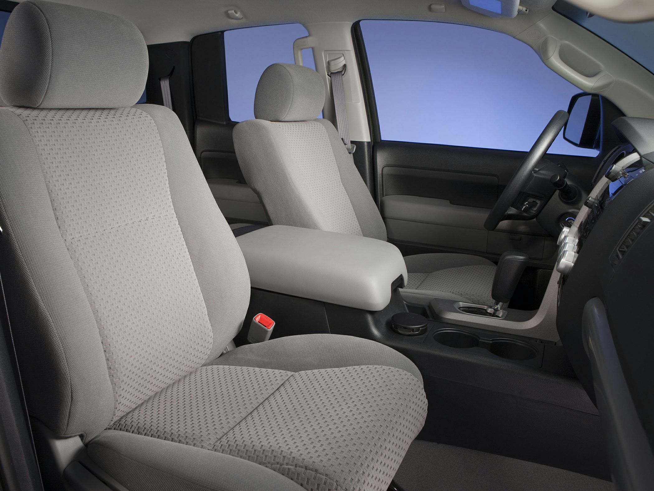 Fabric front bucket seats with central console and gear shift in truck cabin