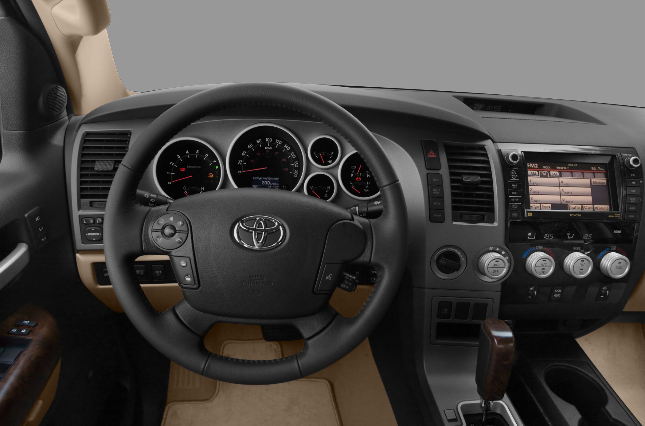 Steering wheel with controls and detailed dashboard of a pickup interior.