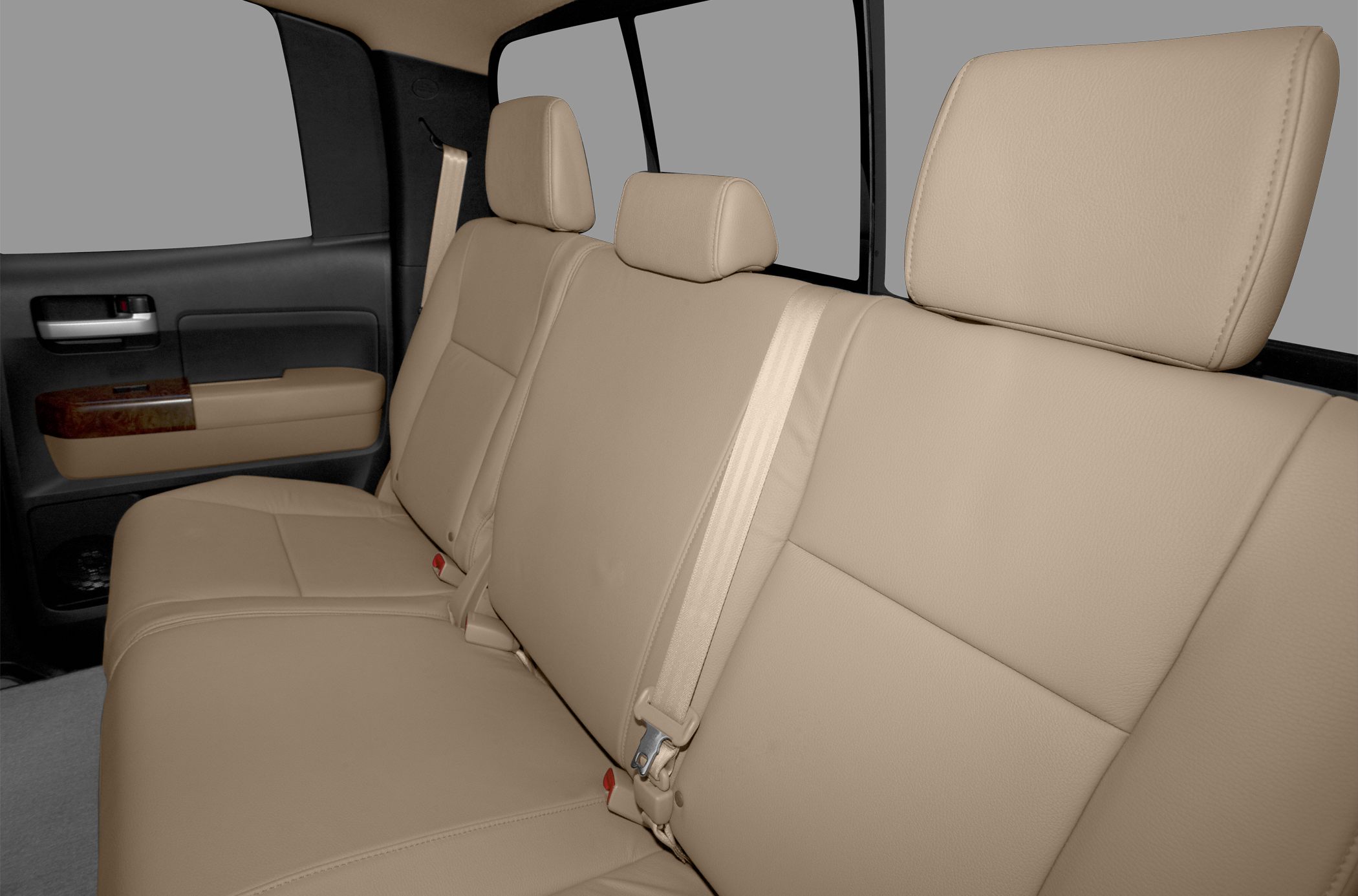 Beige leather rear seats with headrests and seatbelt in vehicle interior