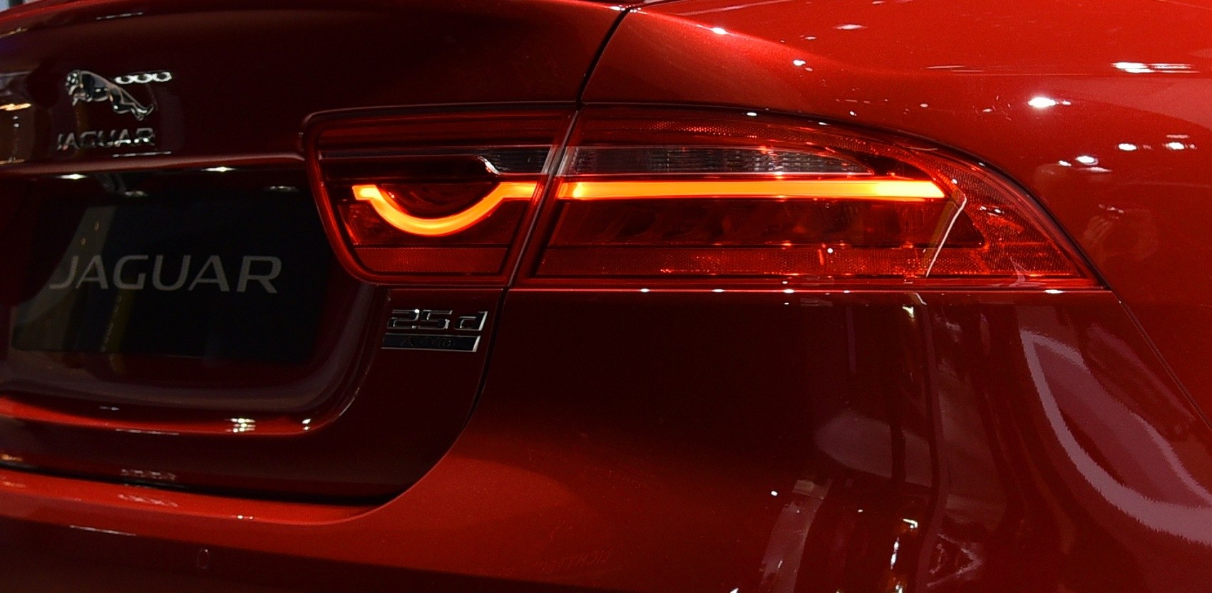 Rear LED taillight and car badge on red vehicle