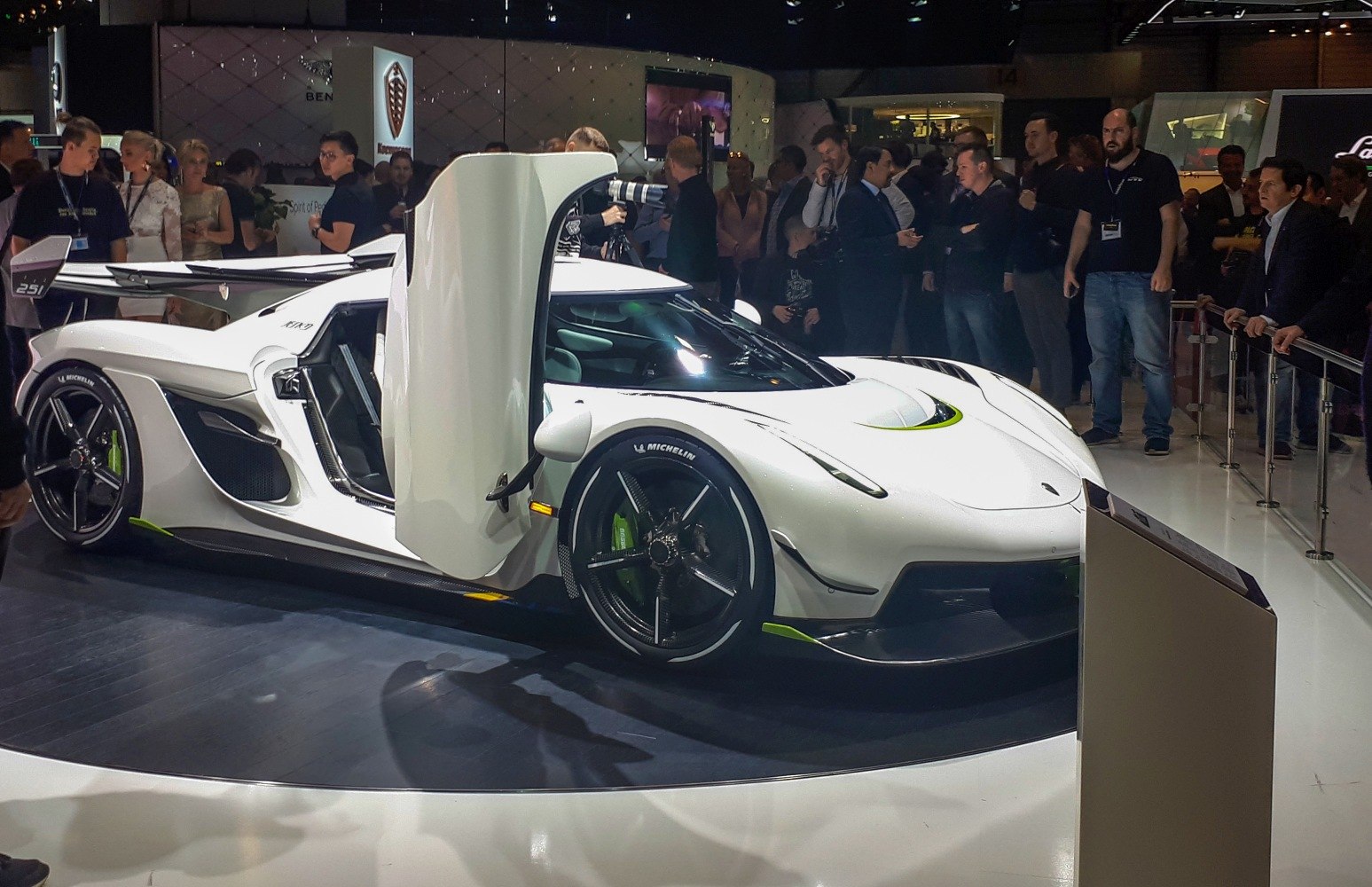 White supercar with butterfly doors, aerodynamic body, and racing wheels