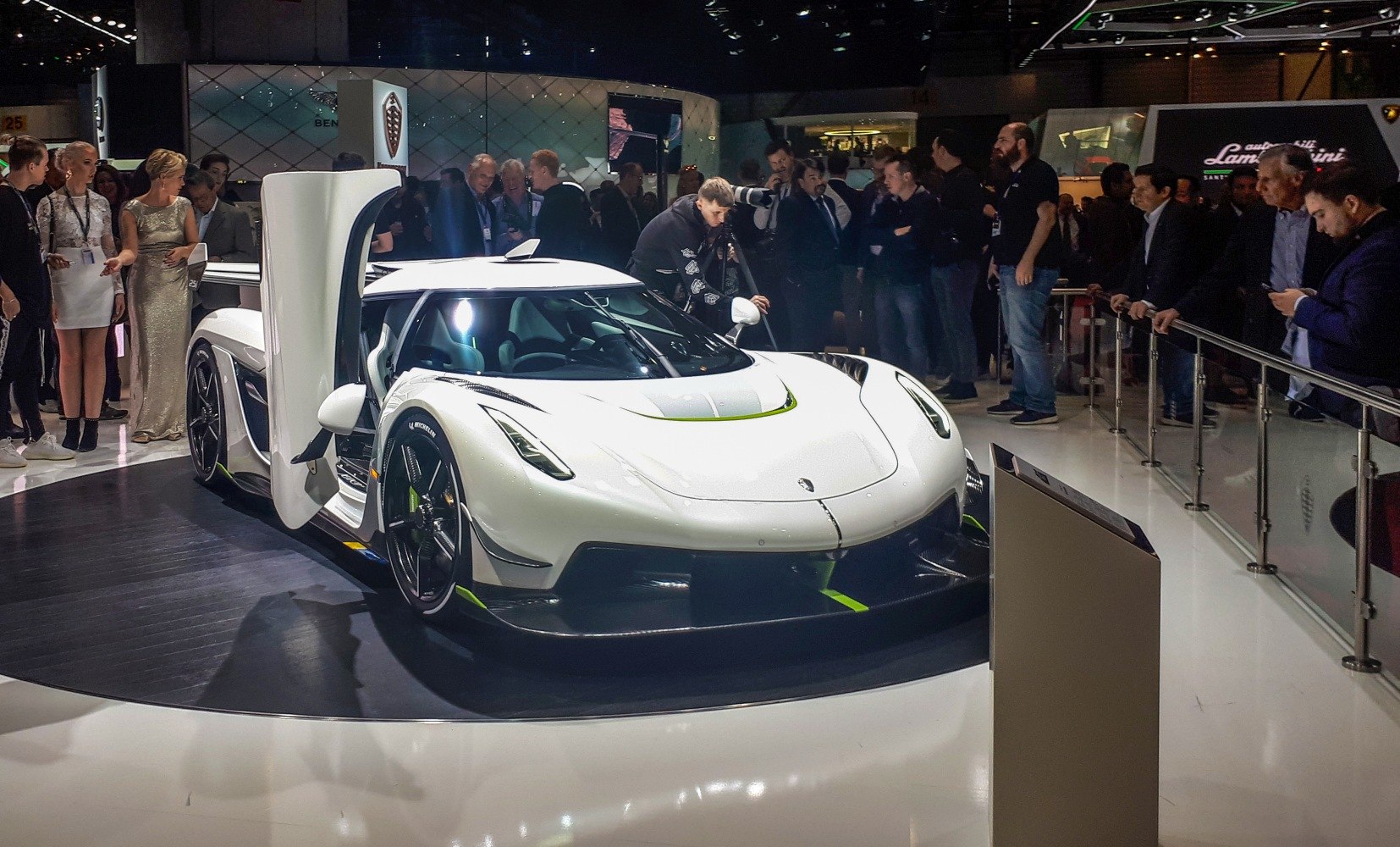 White hypercar with dihedral doors open, sharp aerodynamic front and black wheels