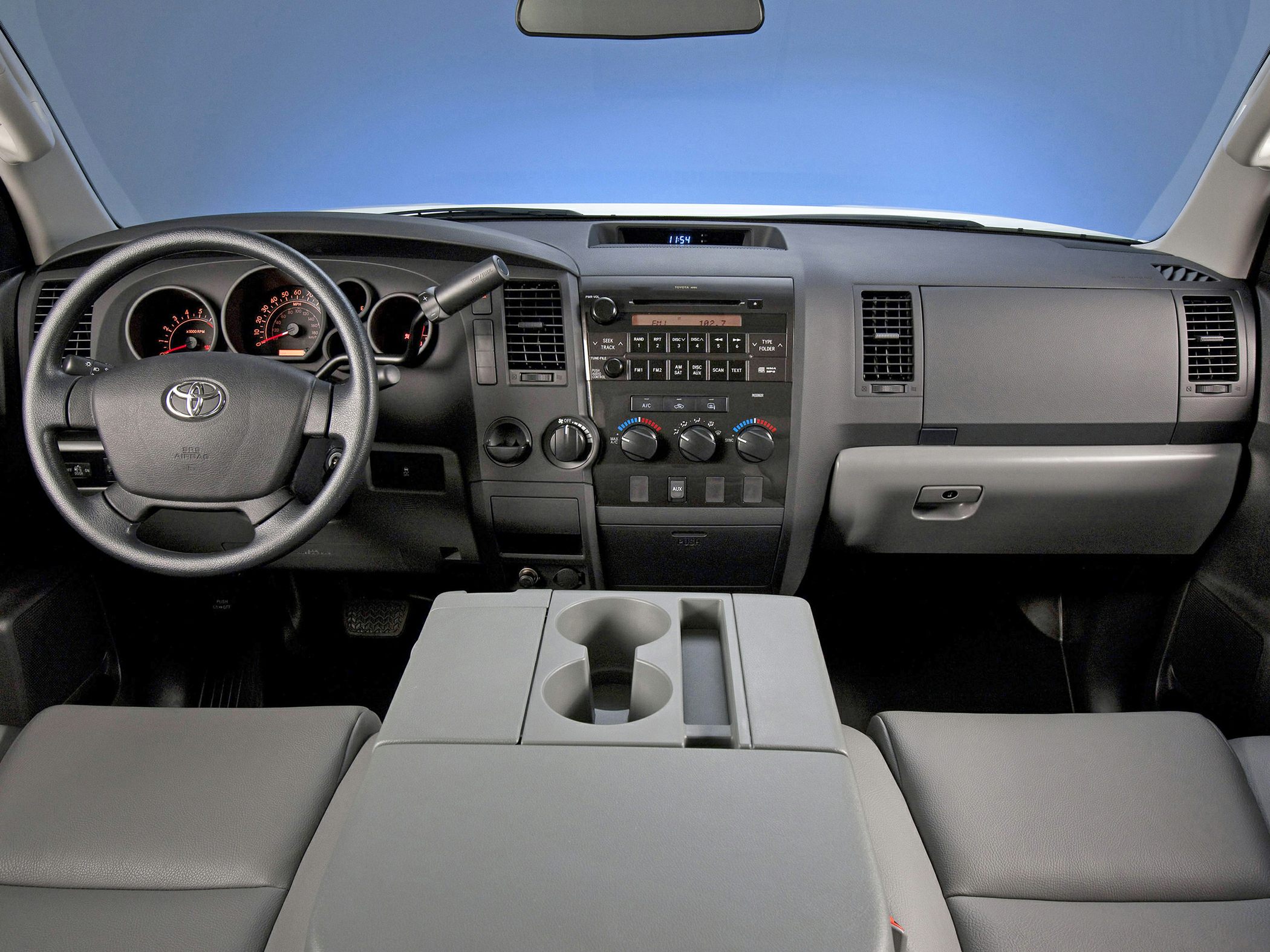 Dashboard, instrument cluster, and center console with cup holders in truck interior