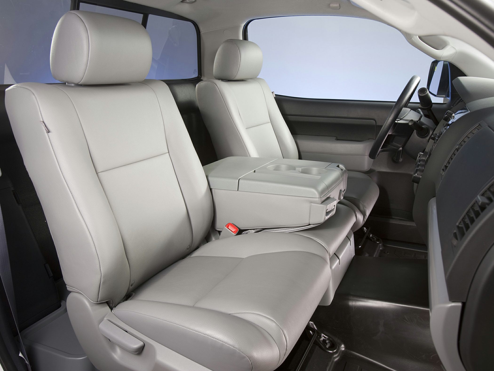 Front seats with center console armrest and cup holders in truck interior