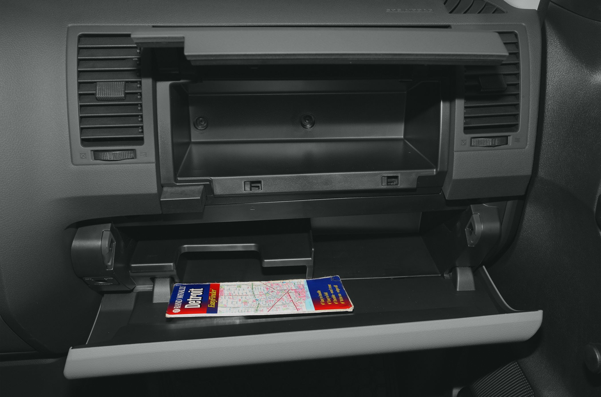 Open glove compartment with dashboard vents in vehicle interior